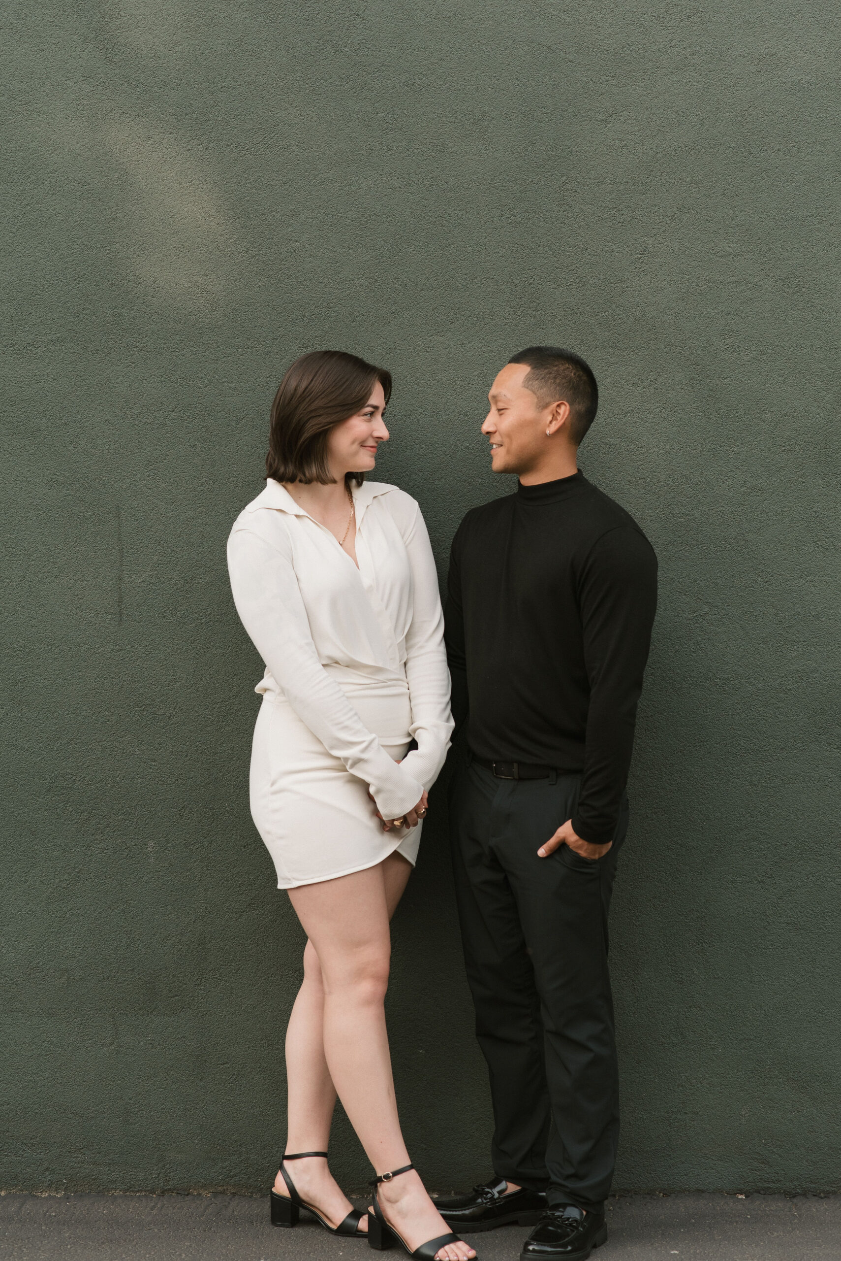 couple standing next to the green wall at editorial couple photoshoot 