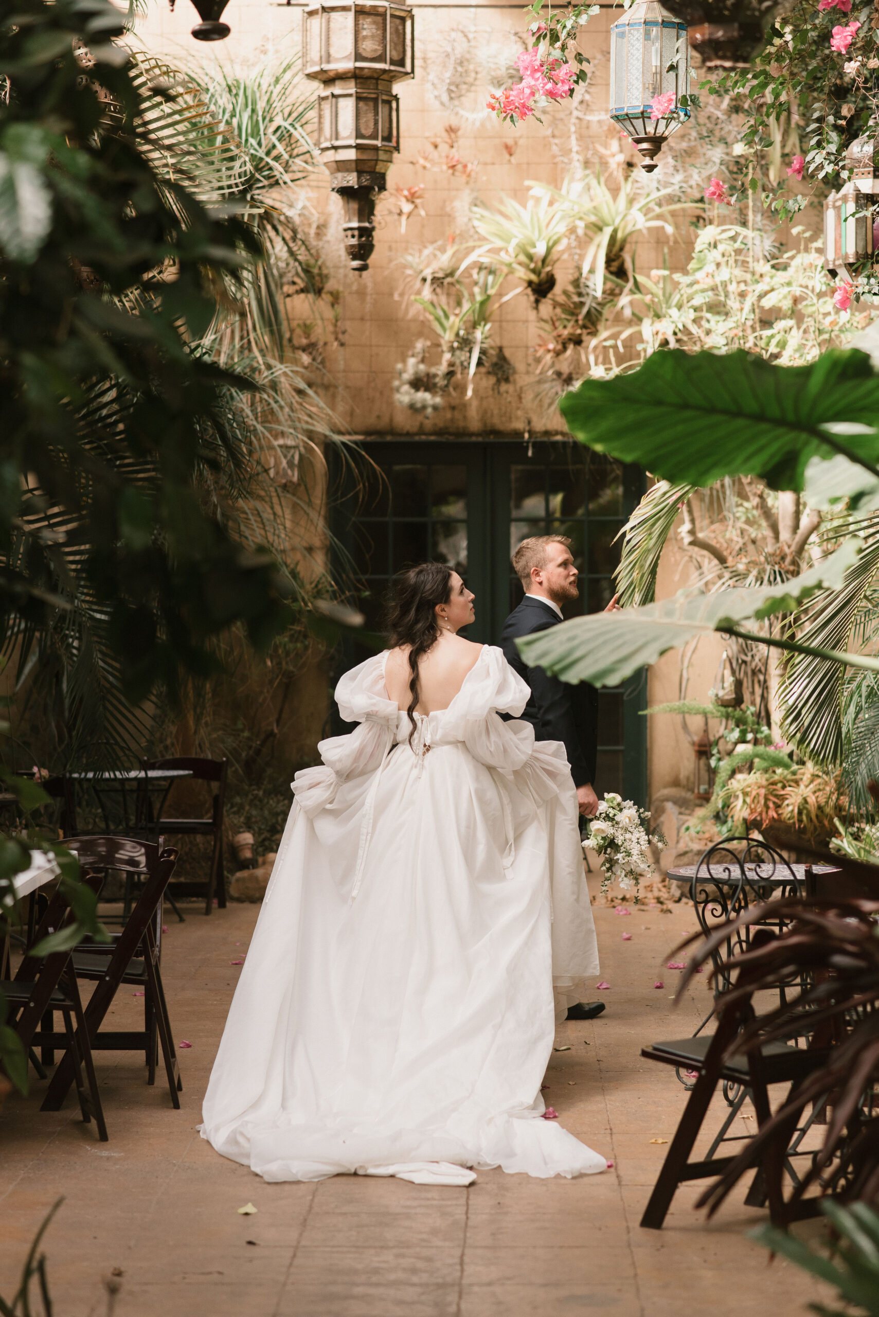 bride and groom walking into beautiful room at european-inspired wedding venue 