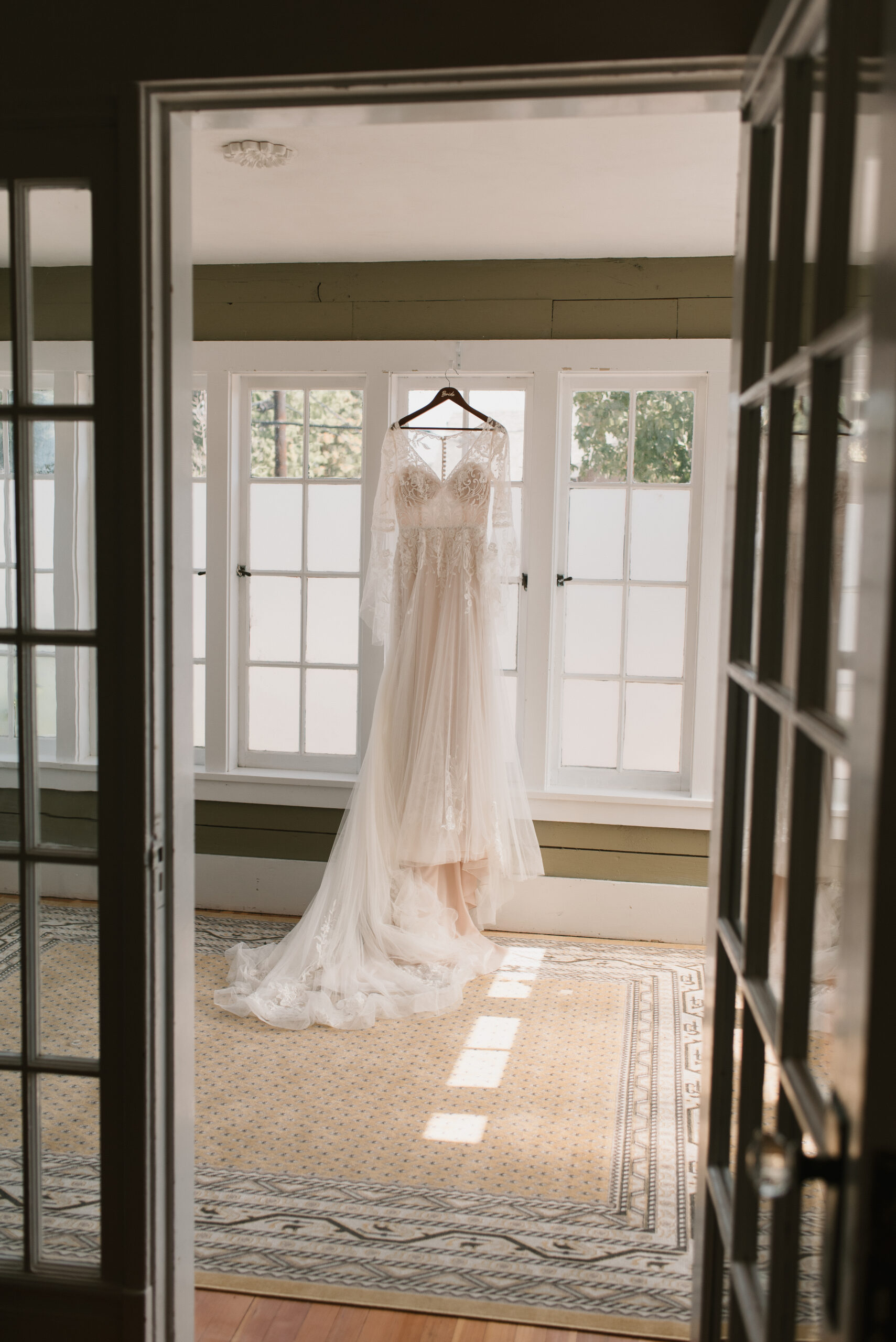 brides dress hanging from window