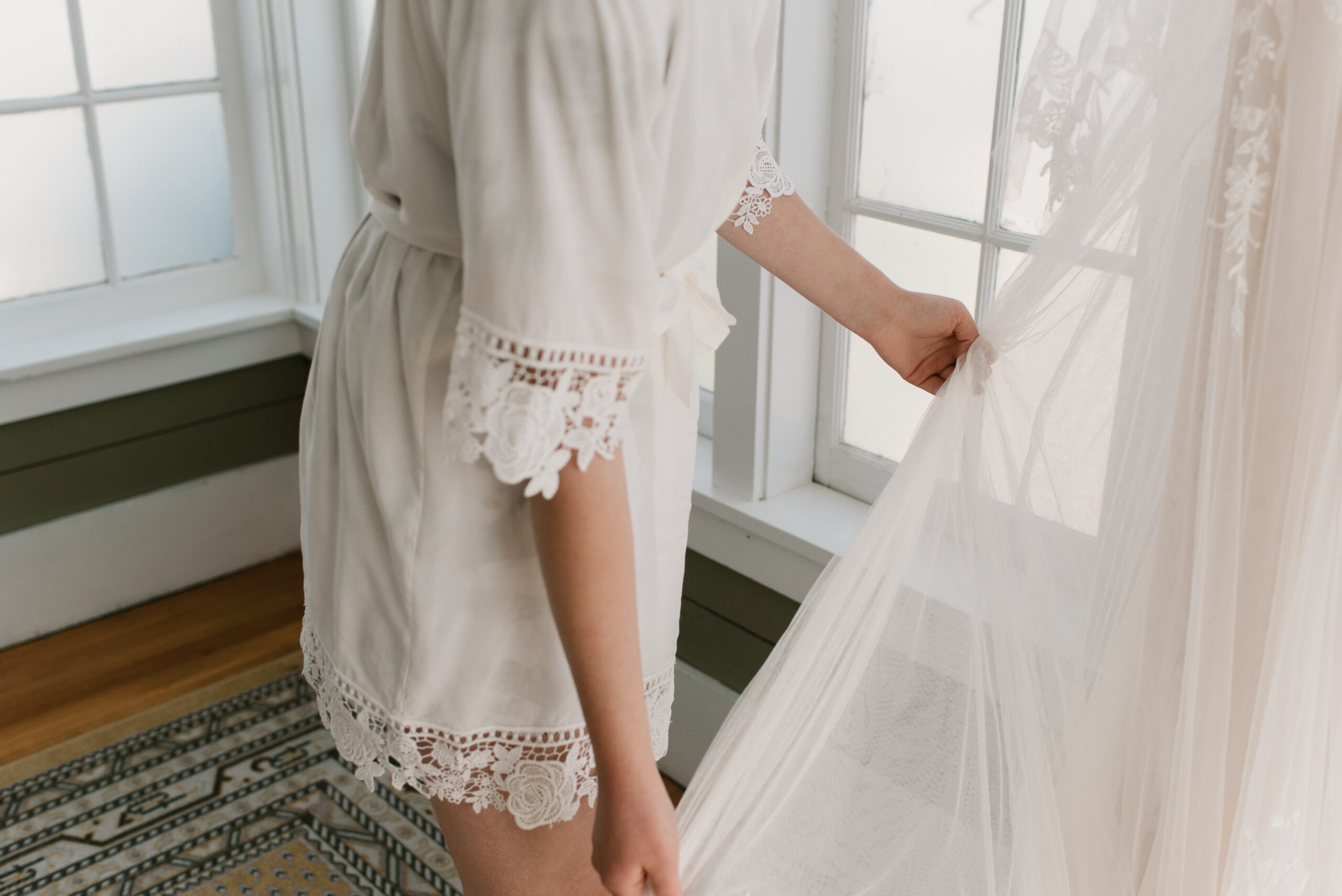 candid wedding photography of bride holding dress