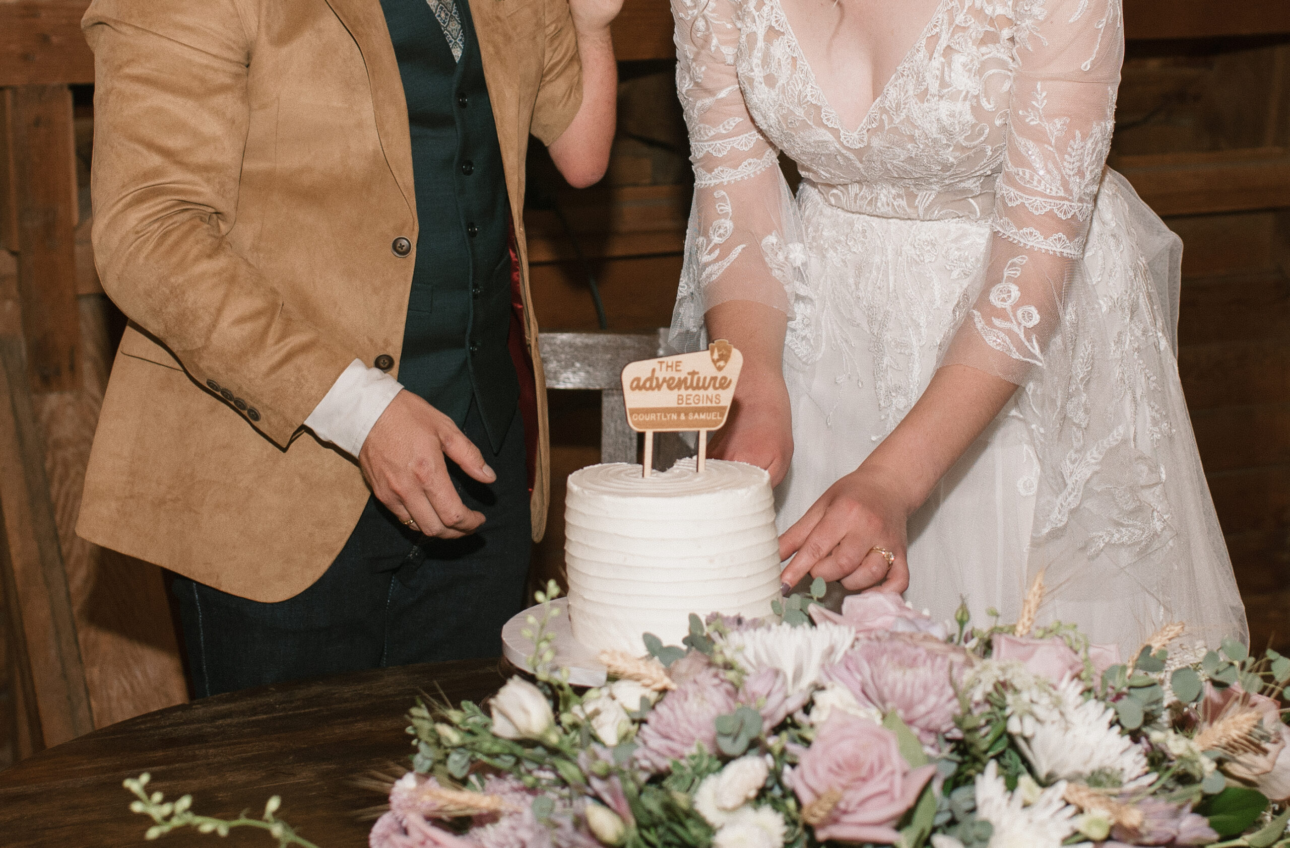 close up of bride and groom cutting the cake 