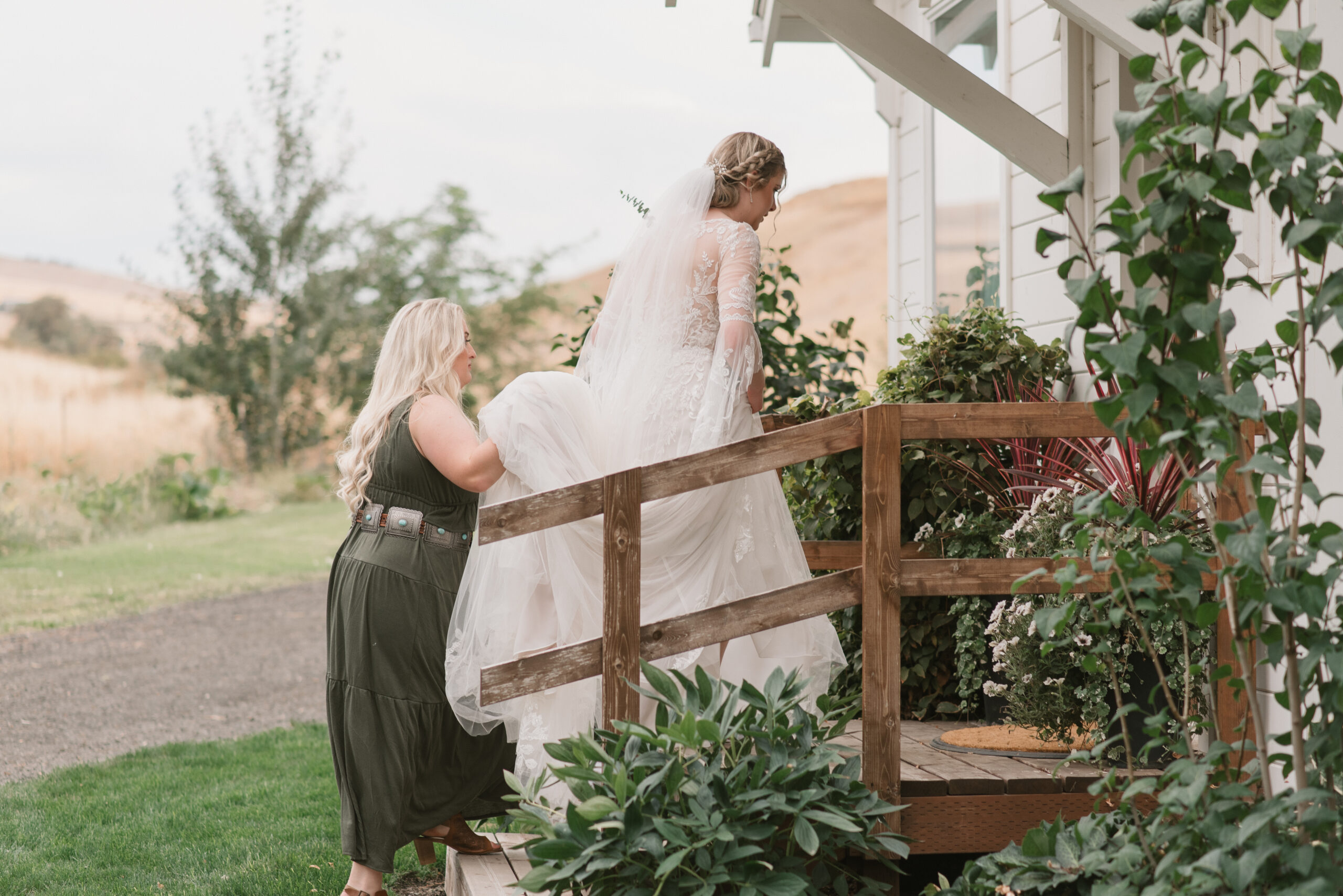 candid wedding photography of bride walking and mother holding dress