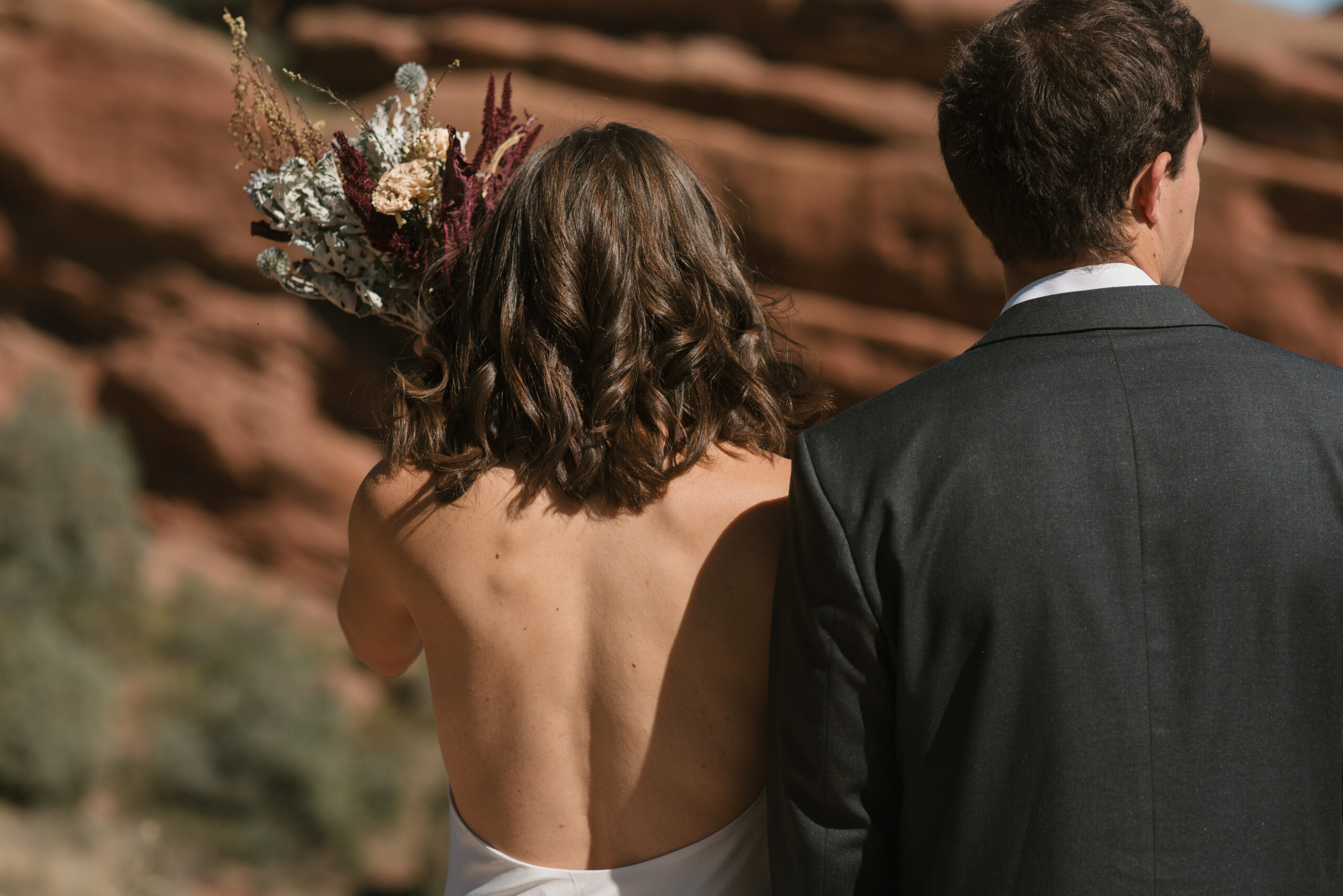 bridal couples backs with red rocks in view