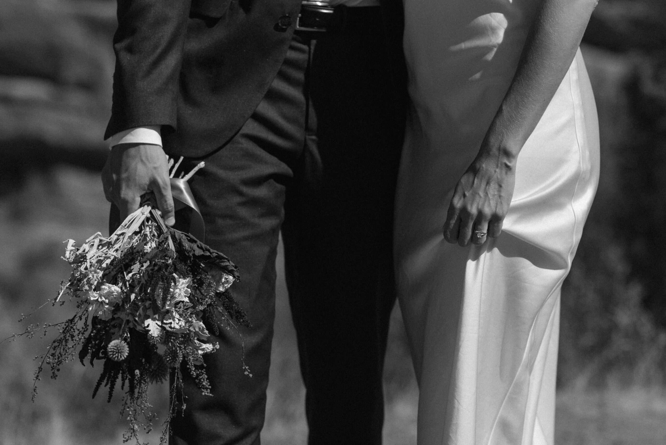black and white shot of bridal couple from the waist down