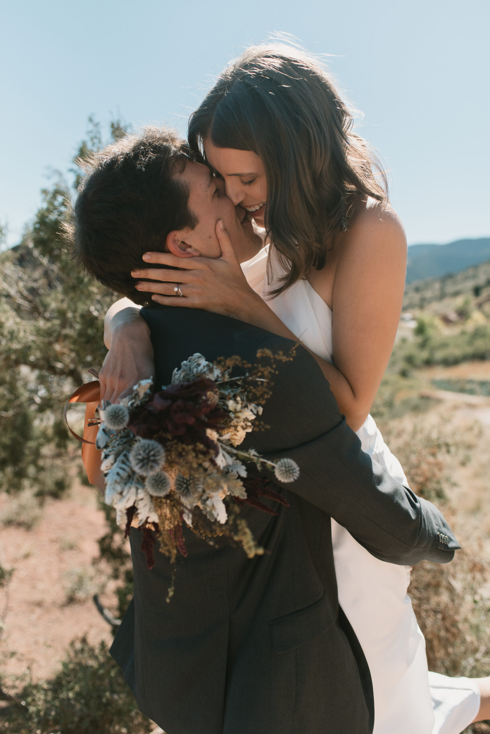 bridal couple holding each other and kissing at colorado elopement 