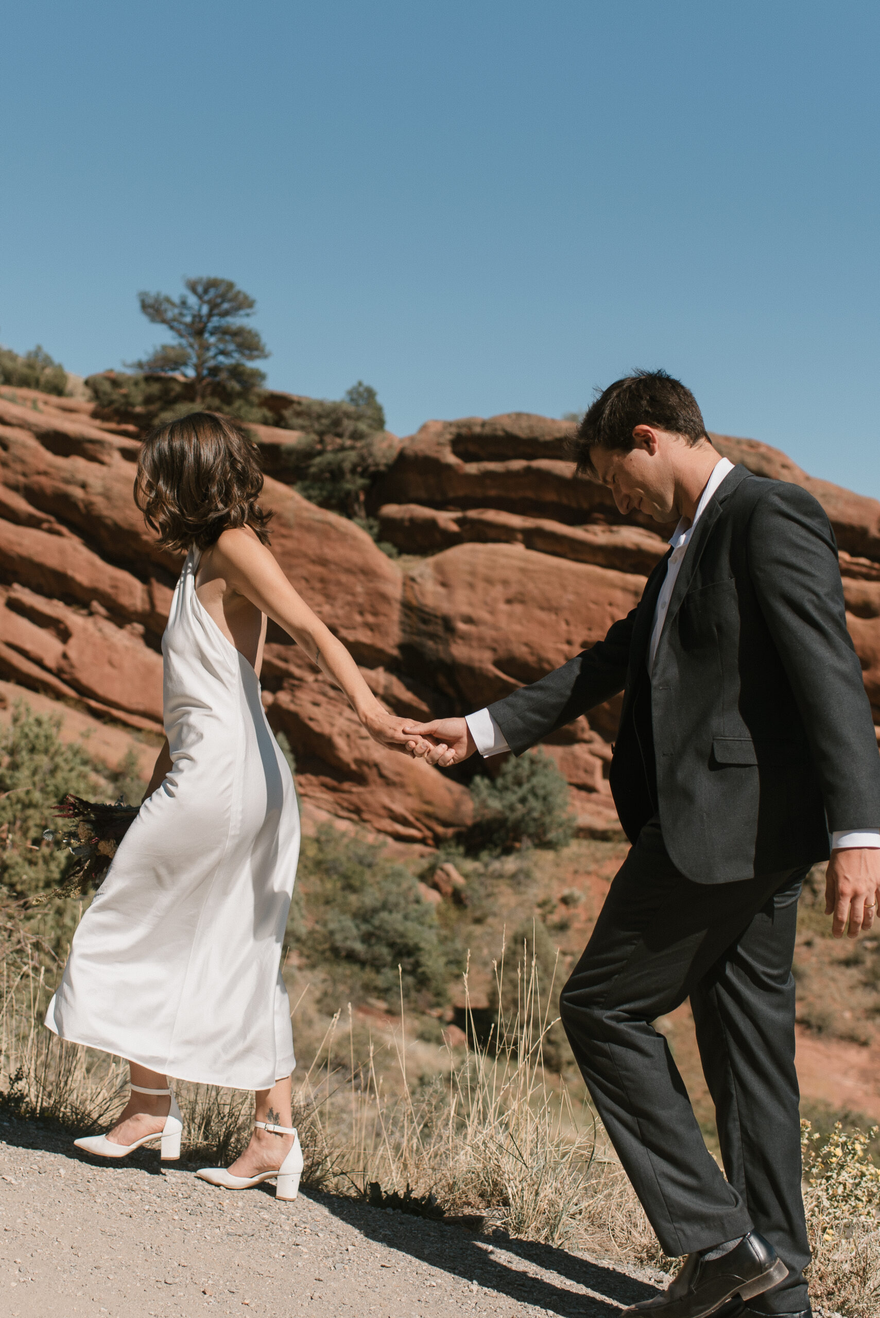 bridal couple walking through the red rocks at colorado elopement 
