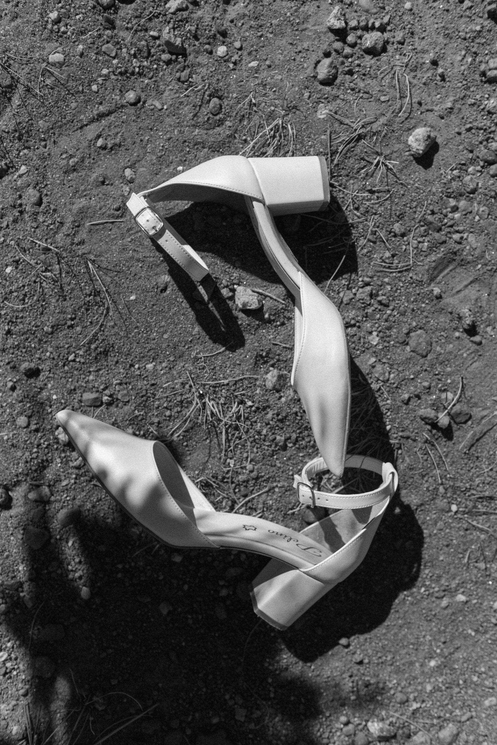 black and white bridal shoes in the dirt 