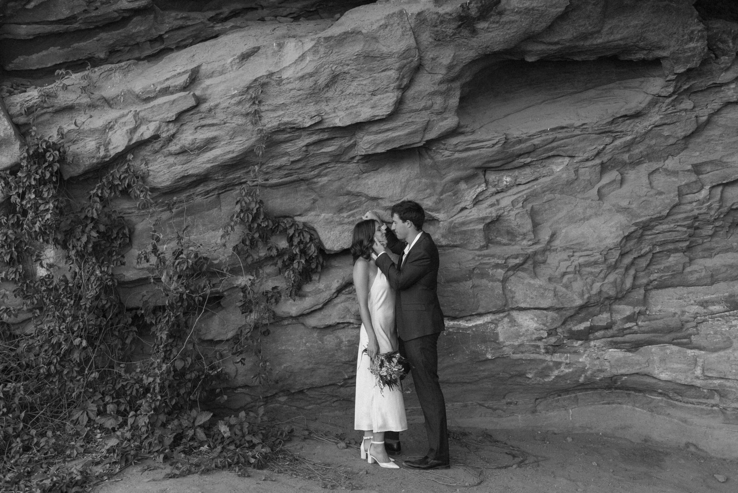 black and white bridal portrait by rocks and vines at colorado elopement 