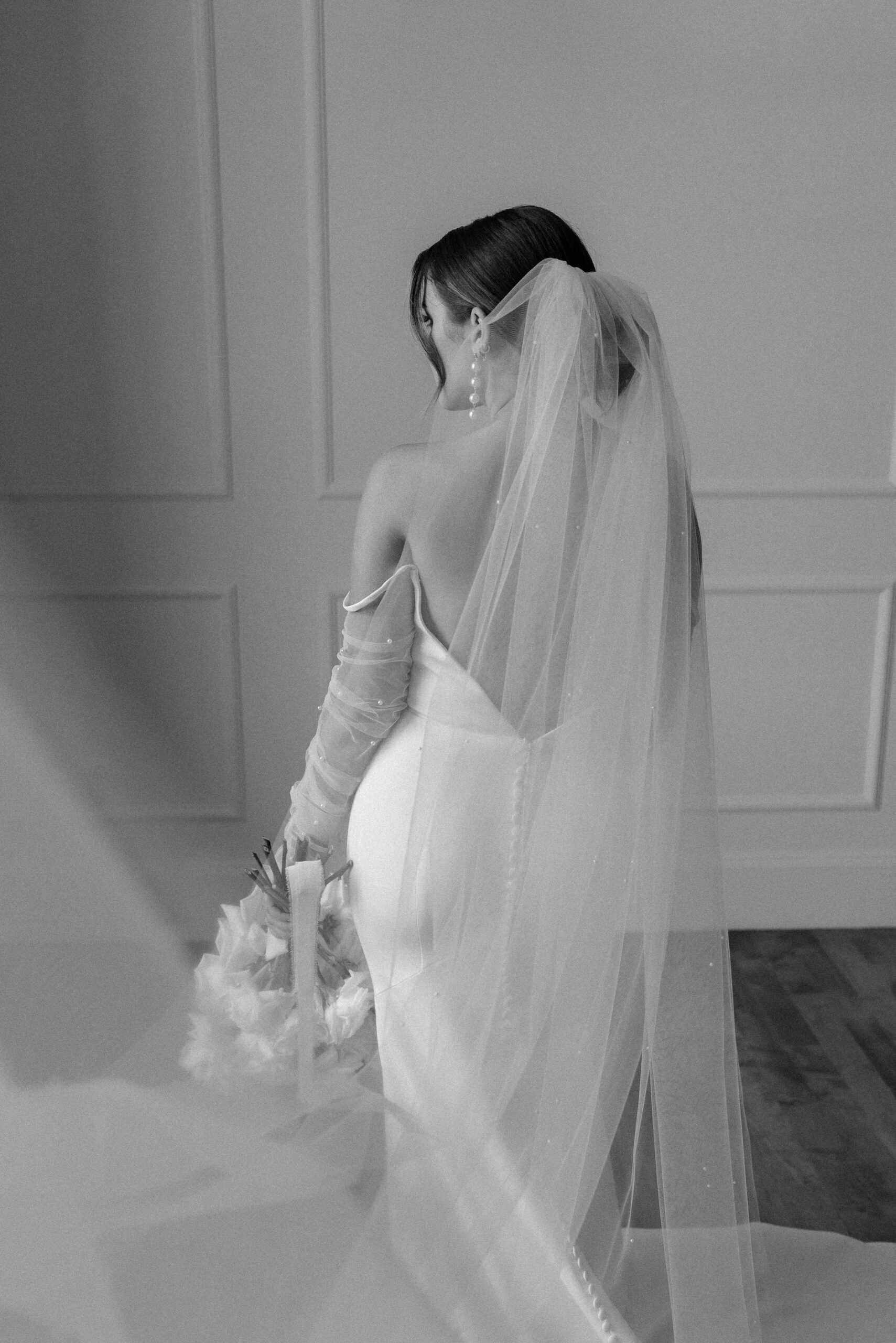 black and white bridal portrait from the back with her veil 