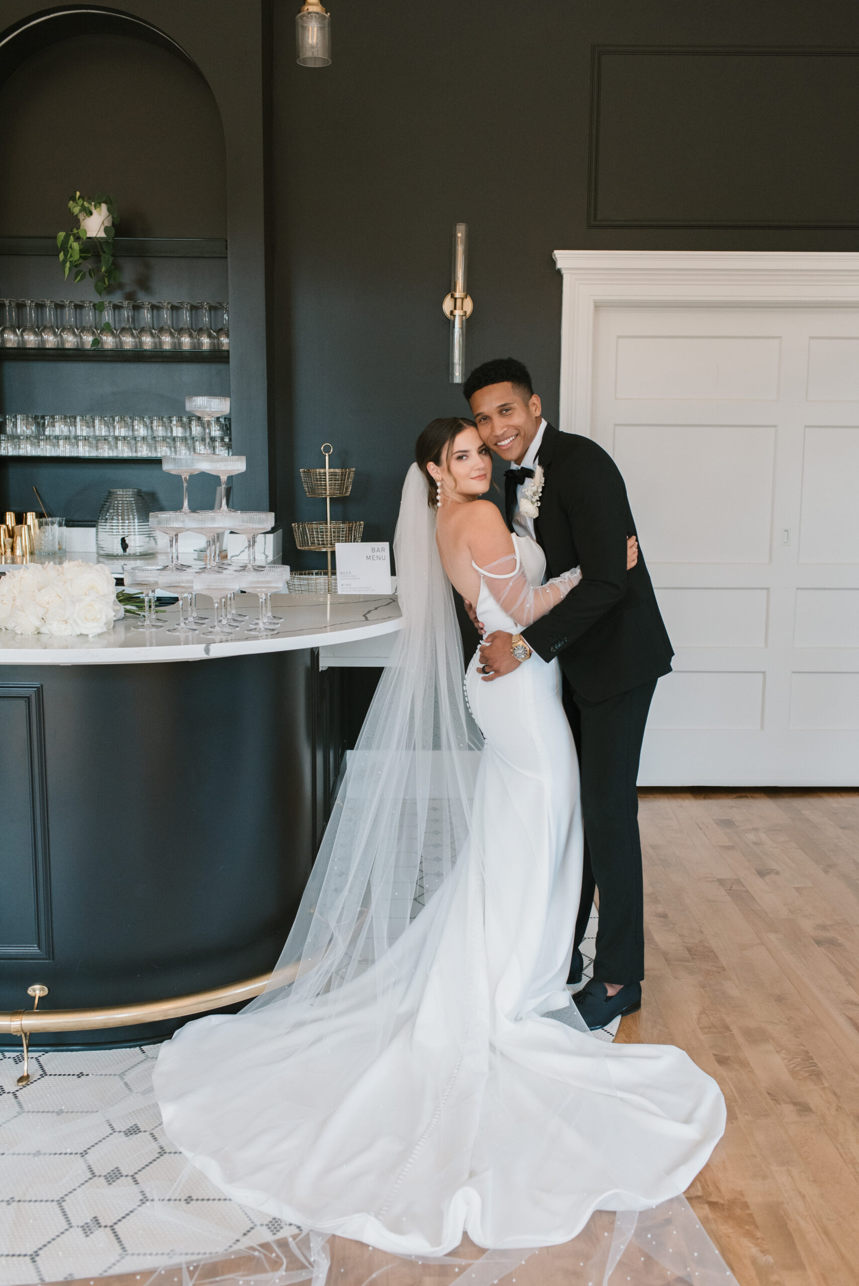 bridal couple holding each other at luxury reception bar 