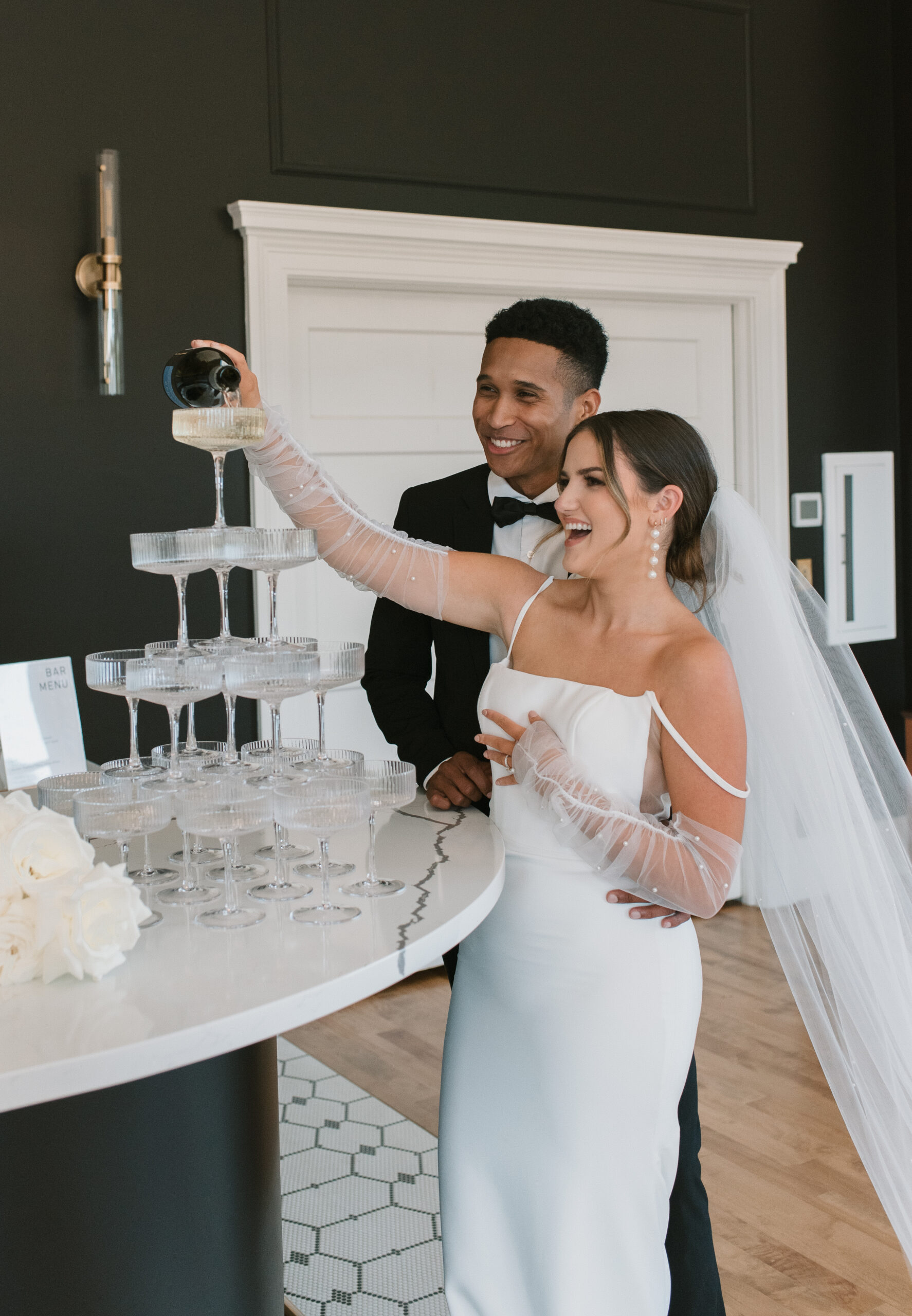 bride and groom pouring champagne onto champagne tower set up