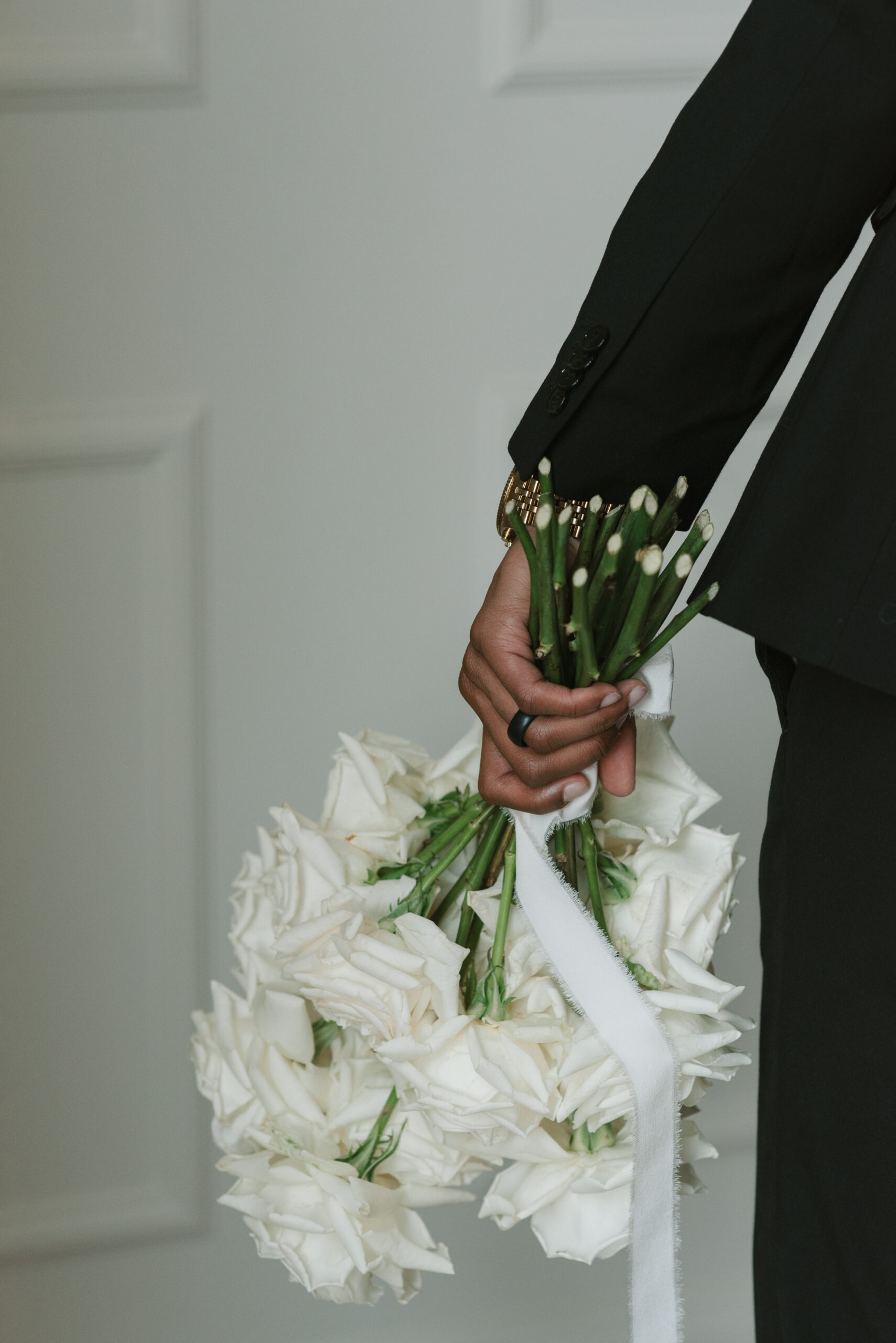 groom holding the bride's flowers