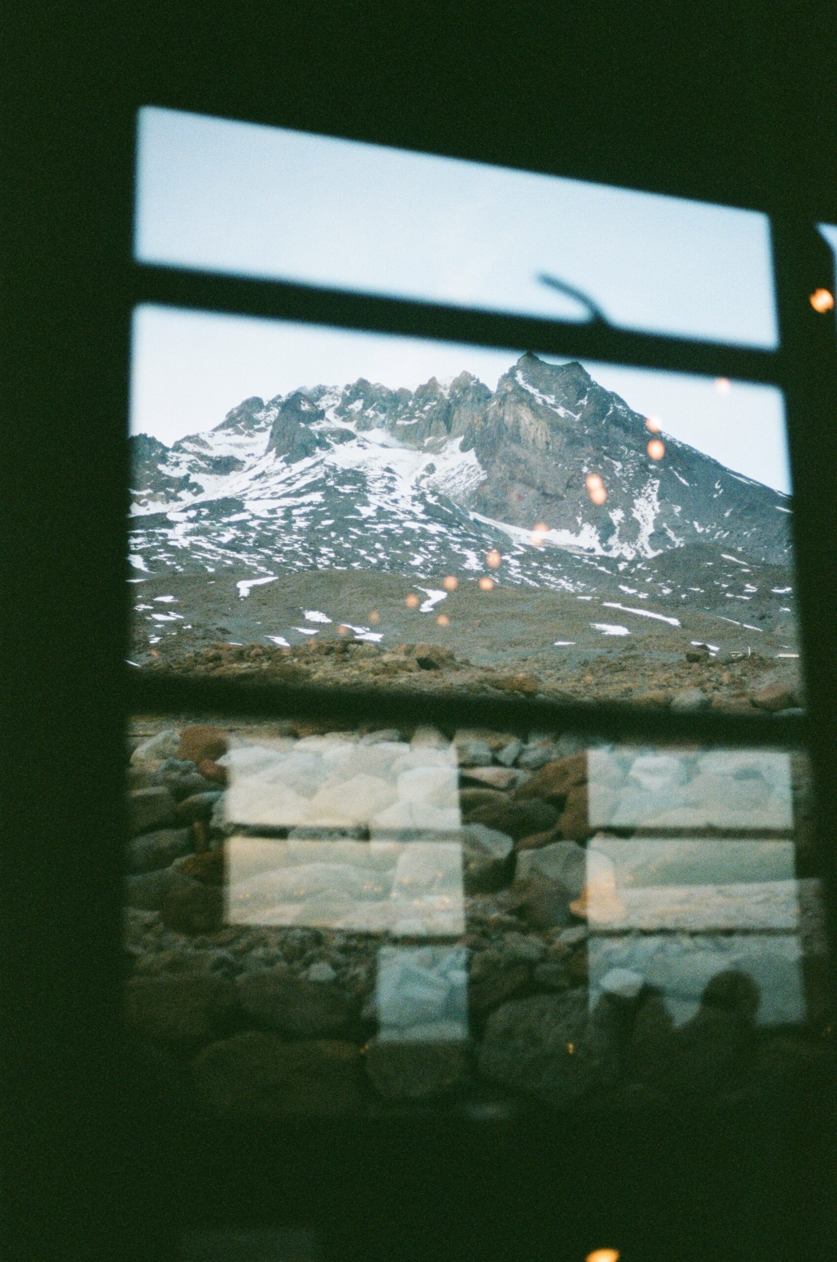 film photo from a wedding reception, looking through the window to the mountain view outside 