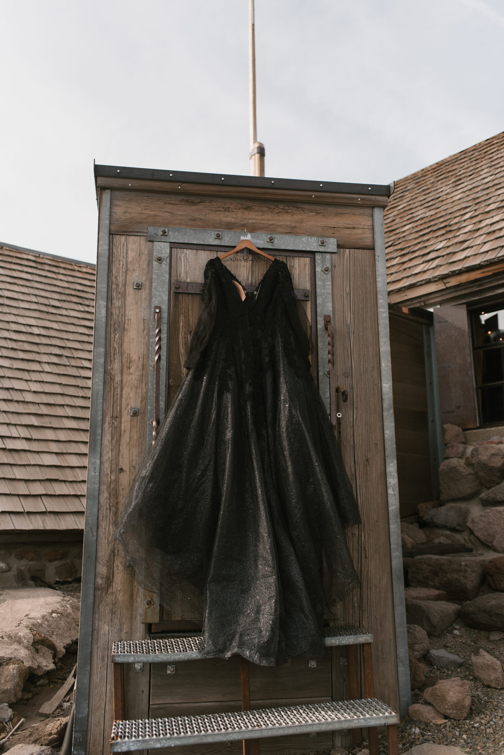 bride's black dress hanging at their small unique wedding 