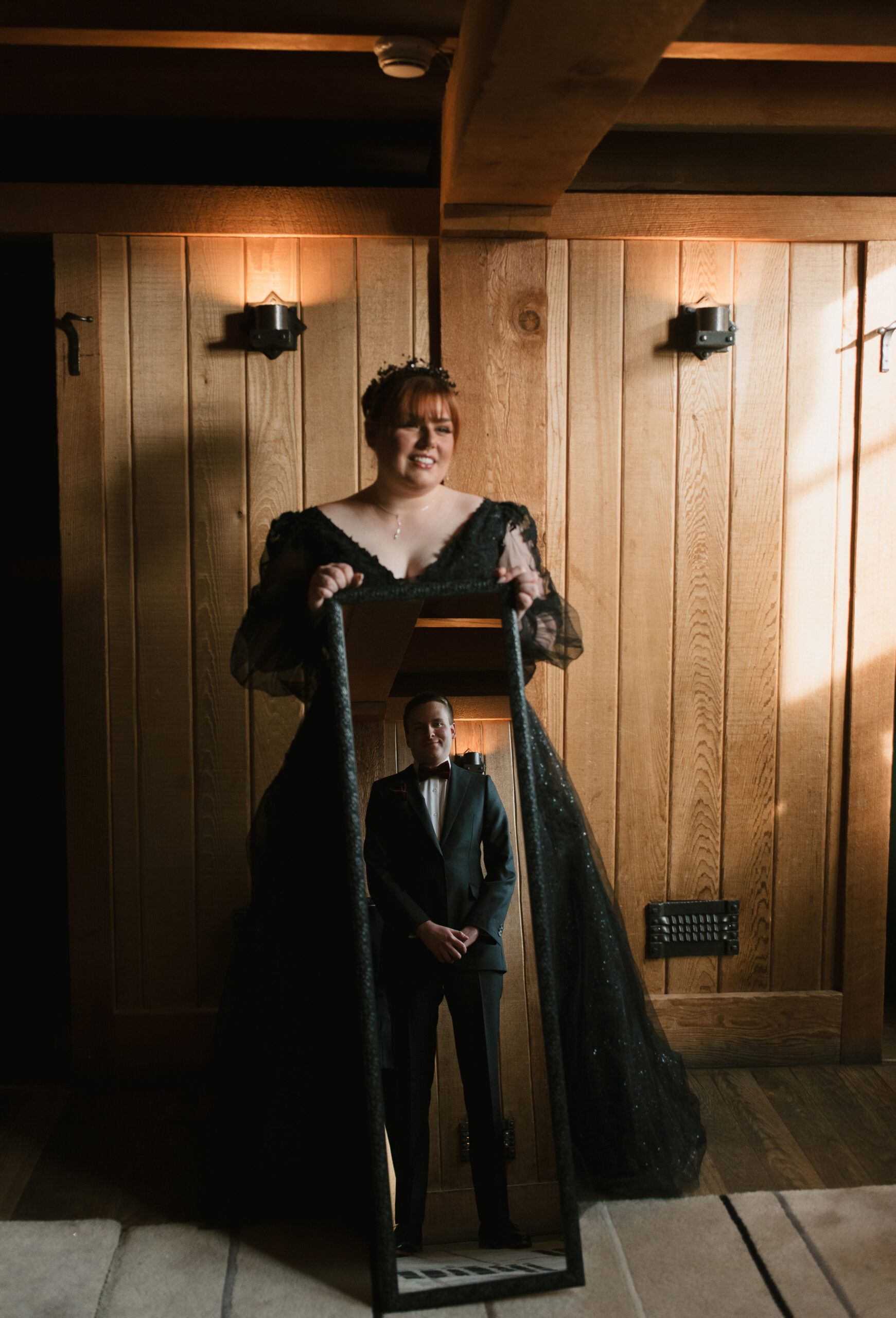 bride holding a mirror with the groom's reflection in it 
