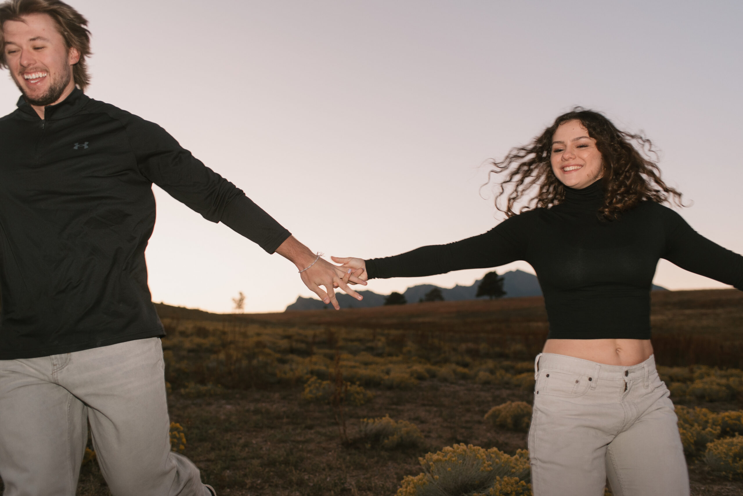couple holding hands smiling as they run close to the camera 
