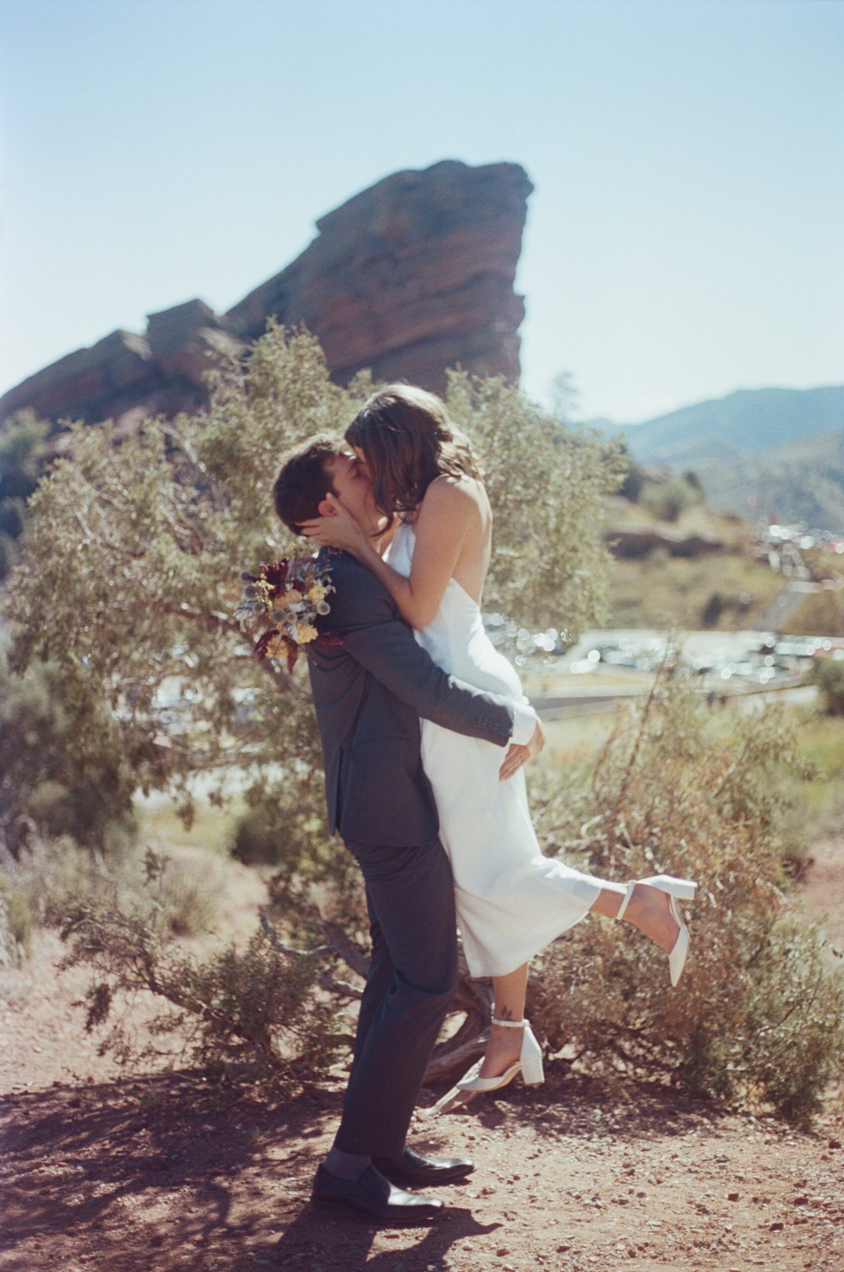 wedding film photography of a groom holding up the bride while kissing in colorado 