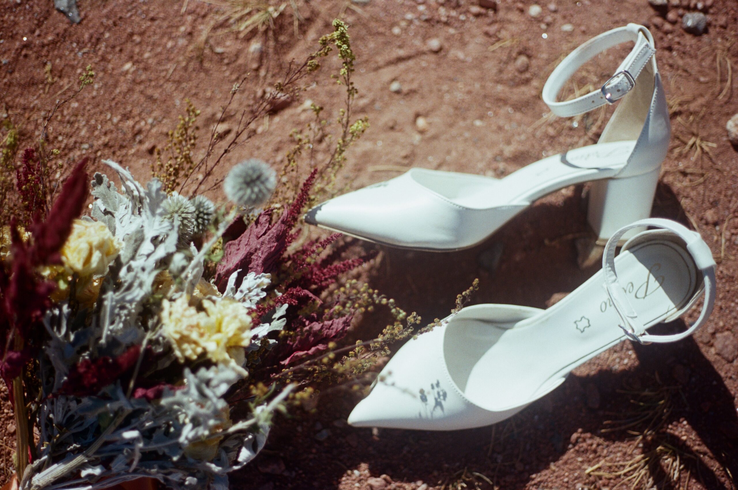 wedding film photography of bride's shoes and flowers 