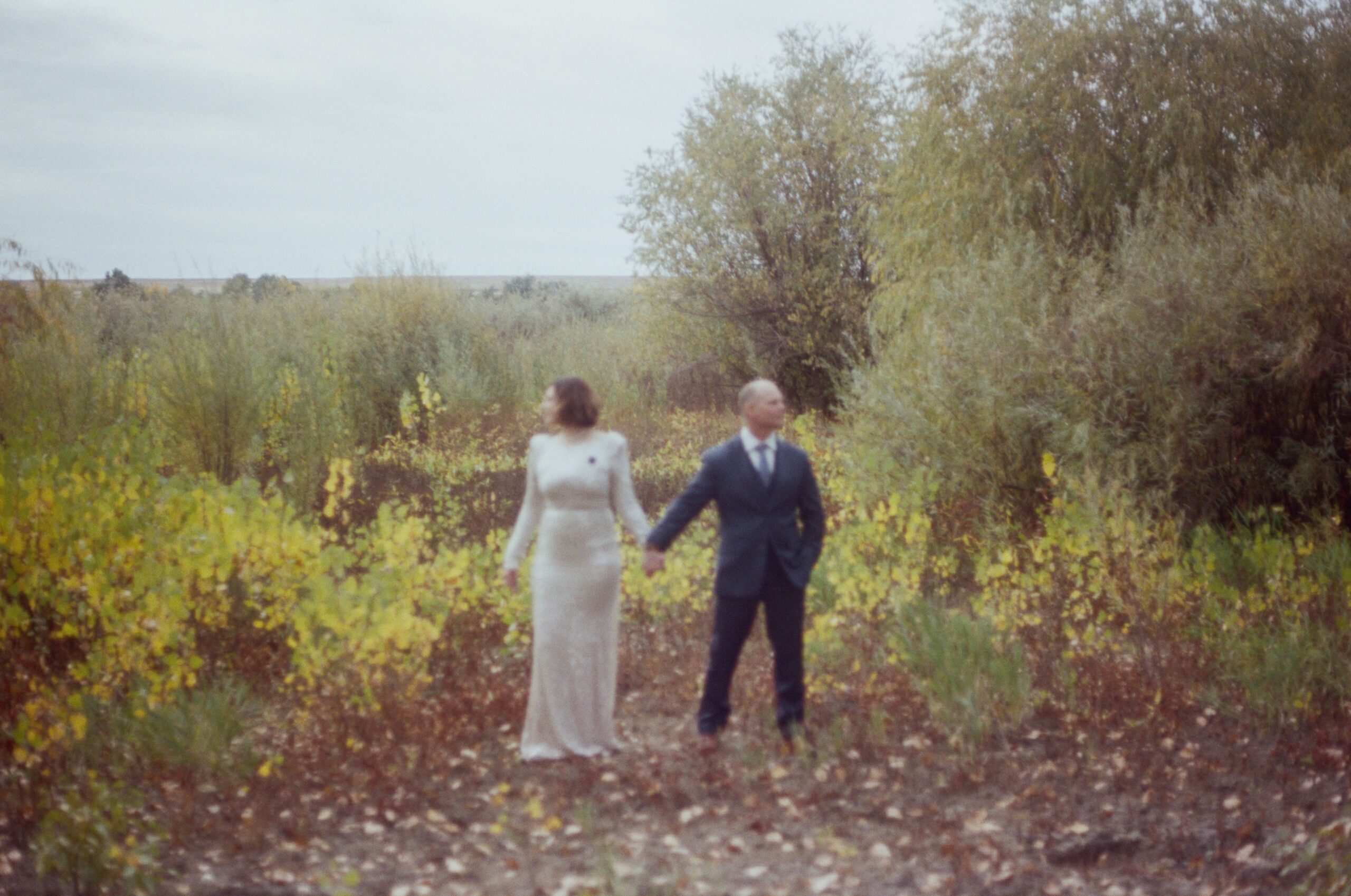 film photo of couple holding hands in nature 