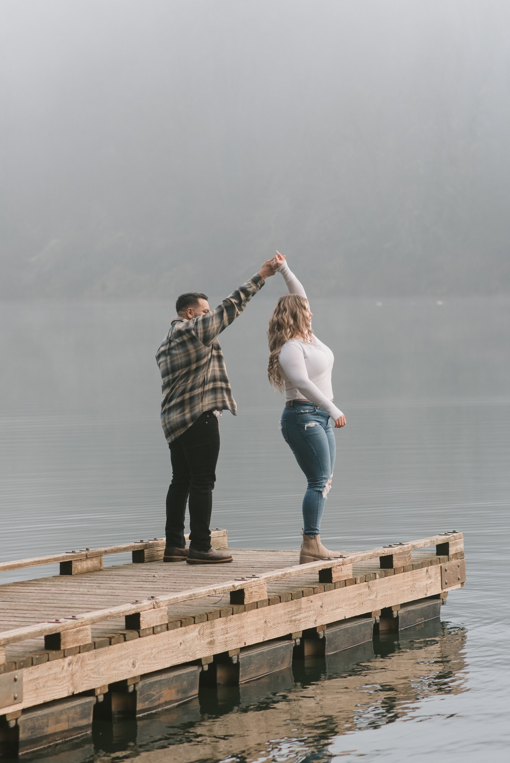 a couple dancing on a dock while its very foggy out captured by an Oregon engagement photographer 