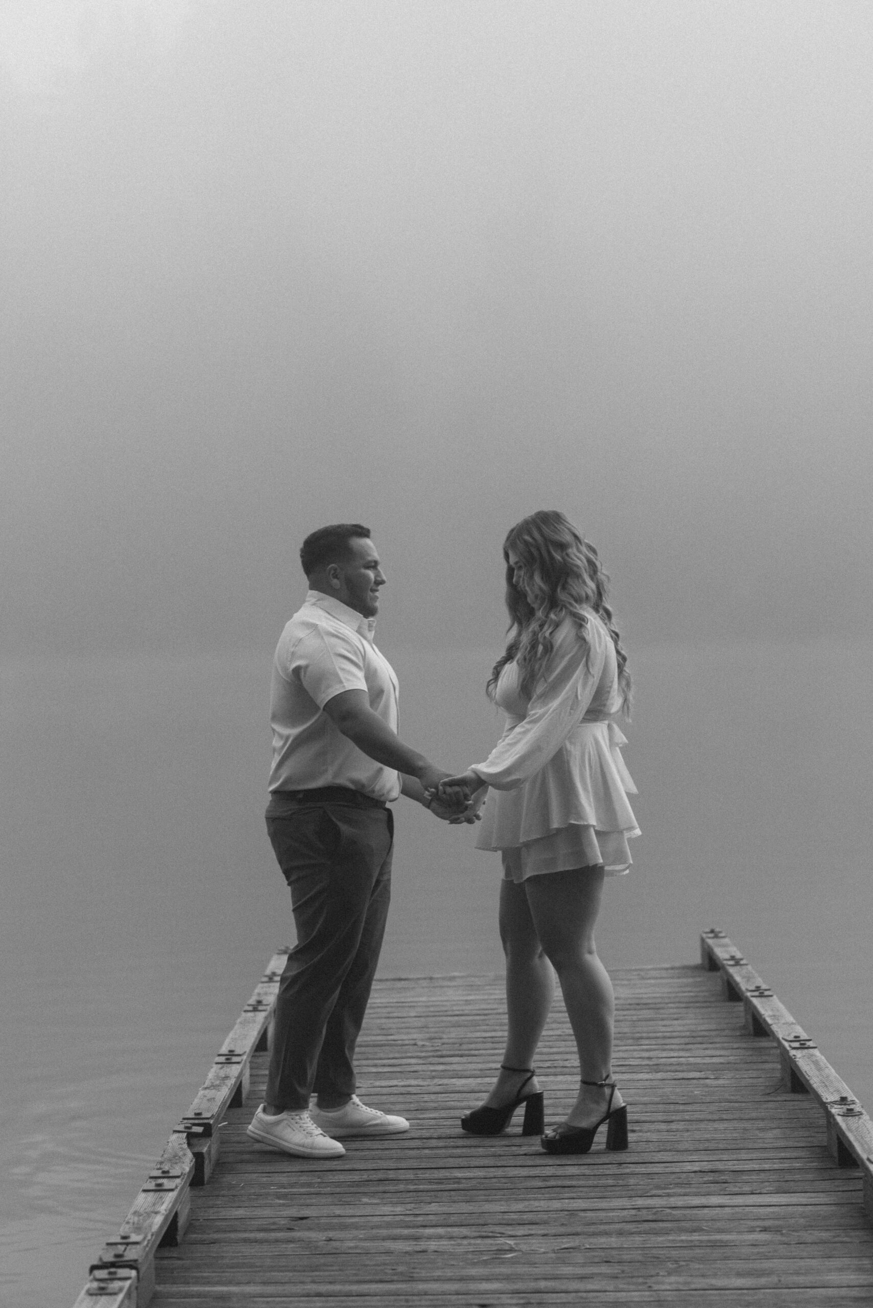 a couple standing and smiling on a dock captured by an Oregon engagement photographer 
