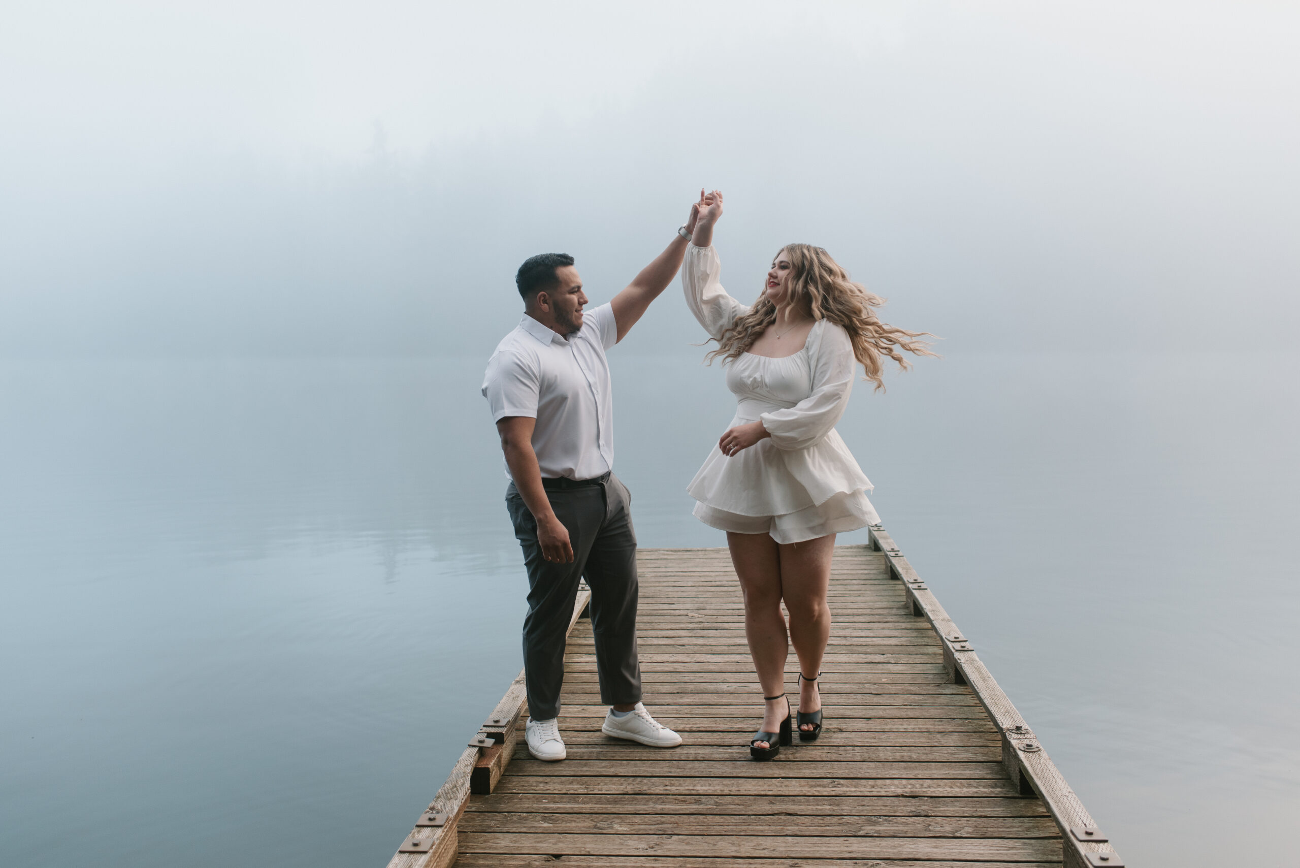 a couple dancing in the fog on a dock captured by an Oregon engagement photographer 