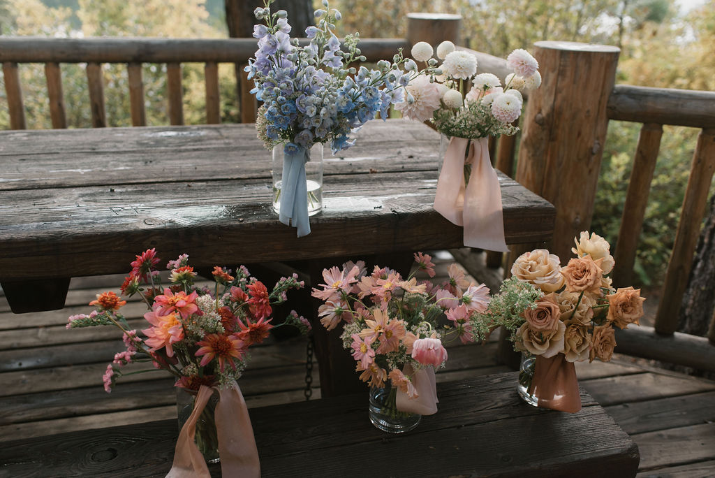 bridesmaids flower bouquets in vases that show the bride's personalized wedding detail choices 
