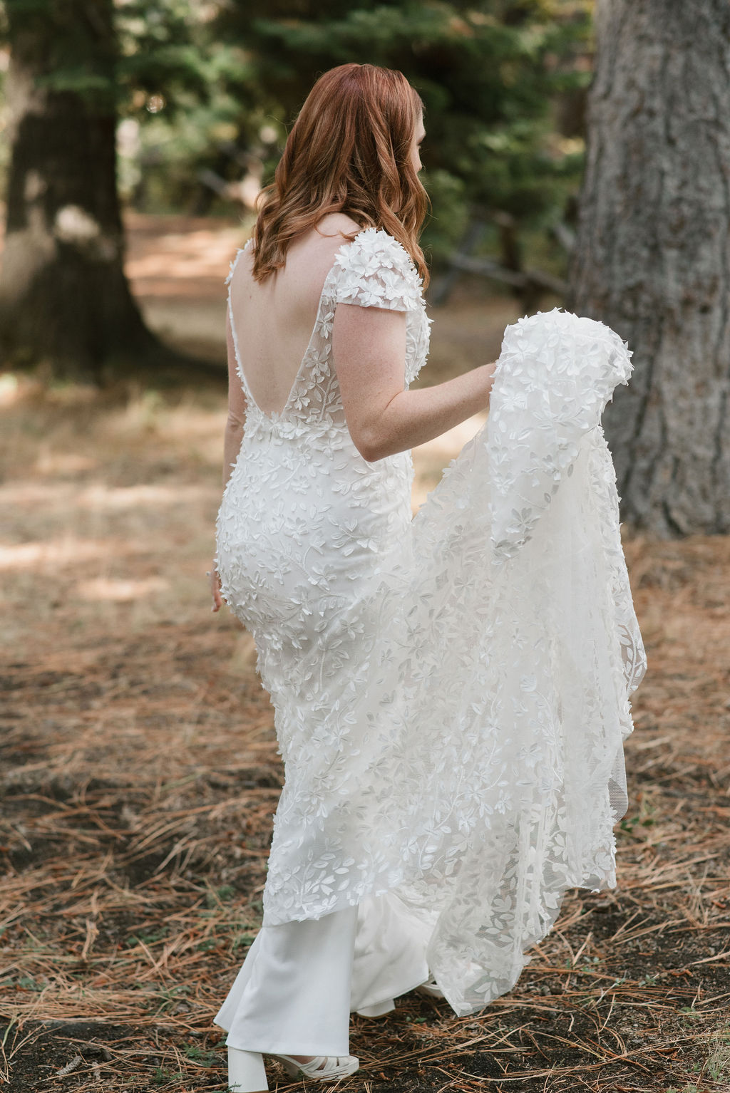 bride walking in the forest holding her dress