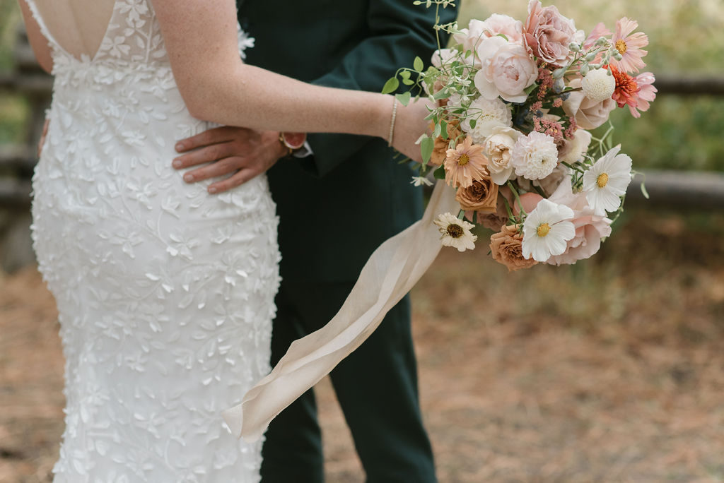 bride and groom from the waist down with focus on the bride's colorful wedding bouquet