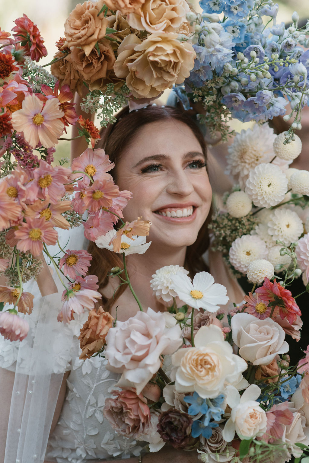 bride portrait with bridesmaids holding flowers around her face 