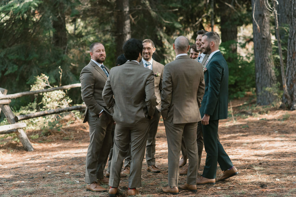 groom and groomsmen standing in a circle talking 
