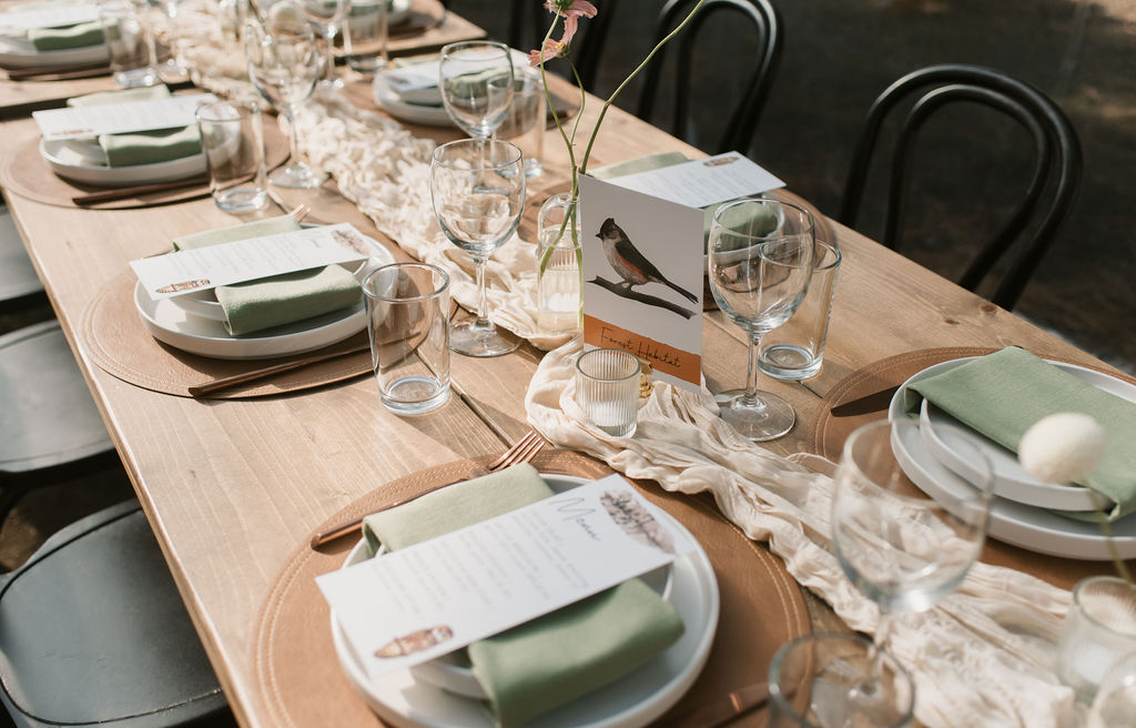 a tablescape with bird place cards showing the couple's personalized wedding details 