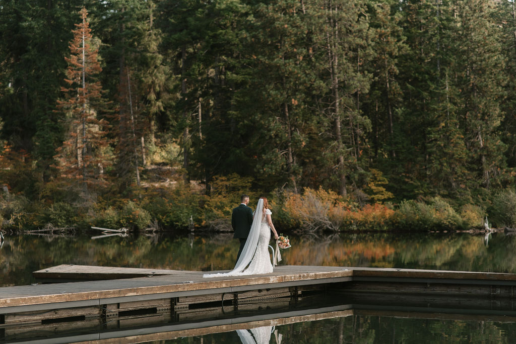 bride and groom walking onto a dock together 