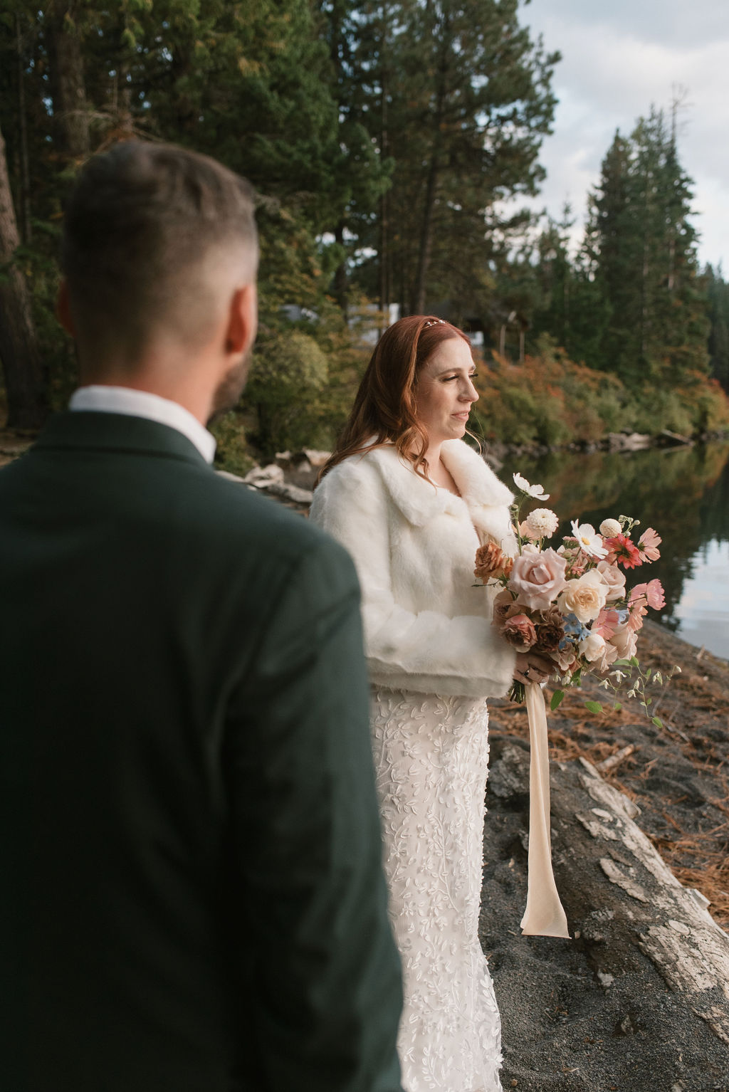 groom is blurry and the bride is in focus during a portrait by the lake