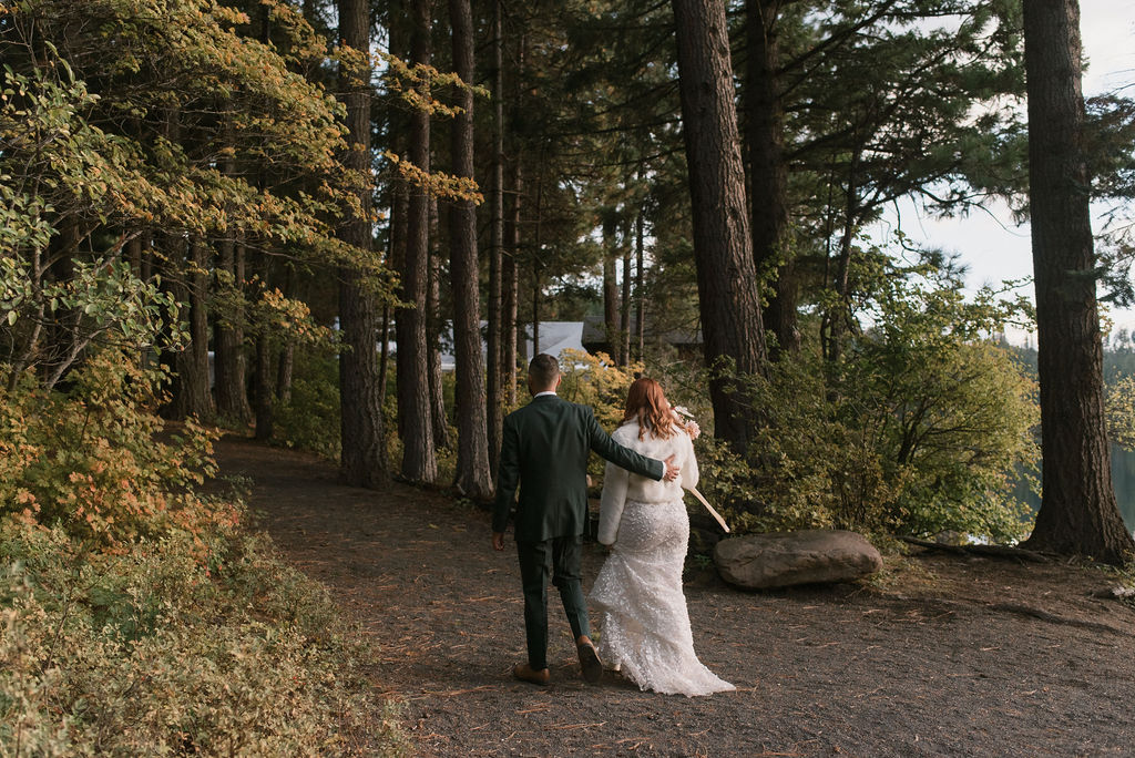bride and groom walking together in the woods