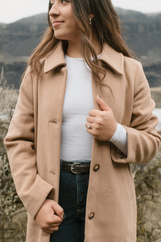 stylish woman in tan trench coat with modern engagement ring