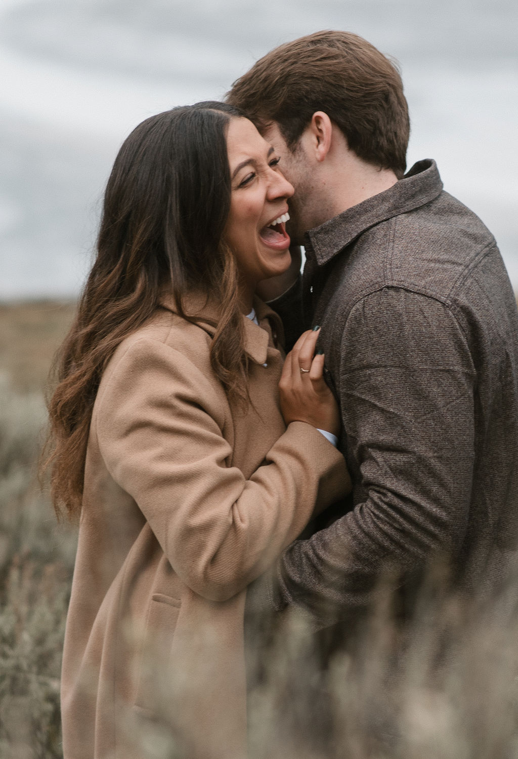 newly engaged couple hugging and laughing together during their modern engagement pictures
