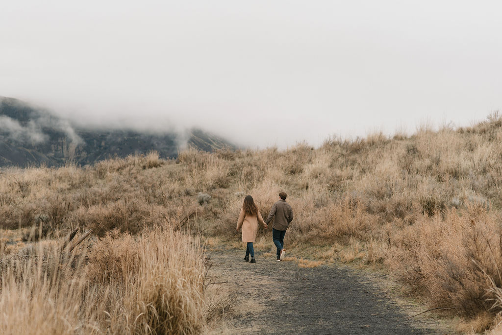couple walking together on a trail during their modern engagement pictures