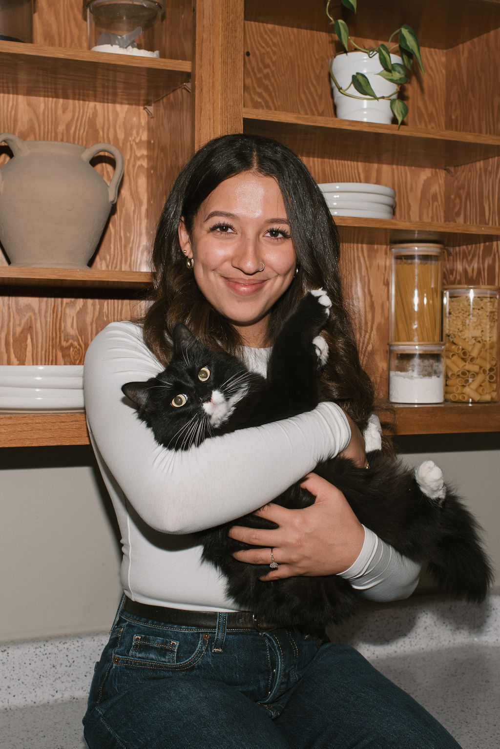 bride to be holding her cat and sitting on her kitchen counter