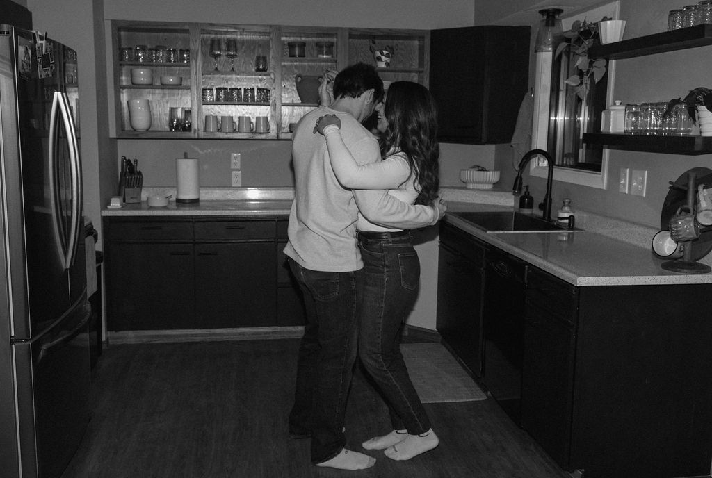 newly engaged couple dancing together in their kitchen 