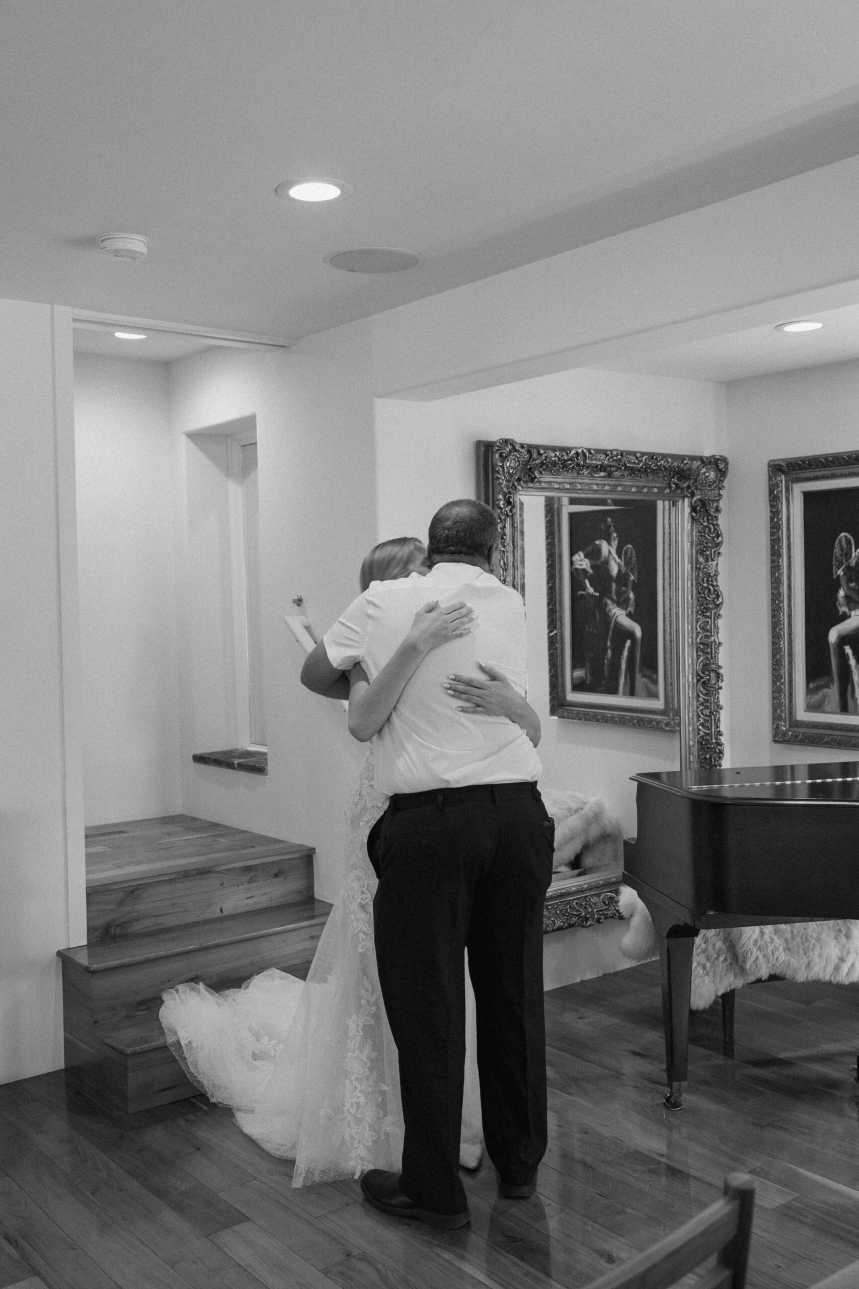 Black and white photo of bride and father embracing