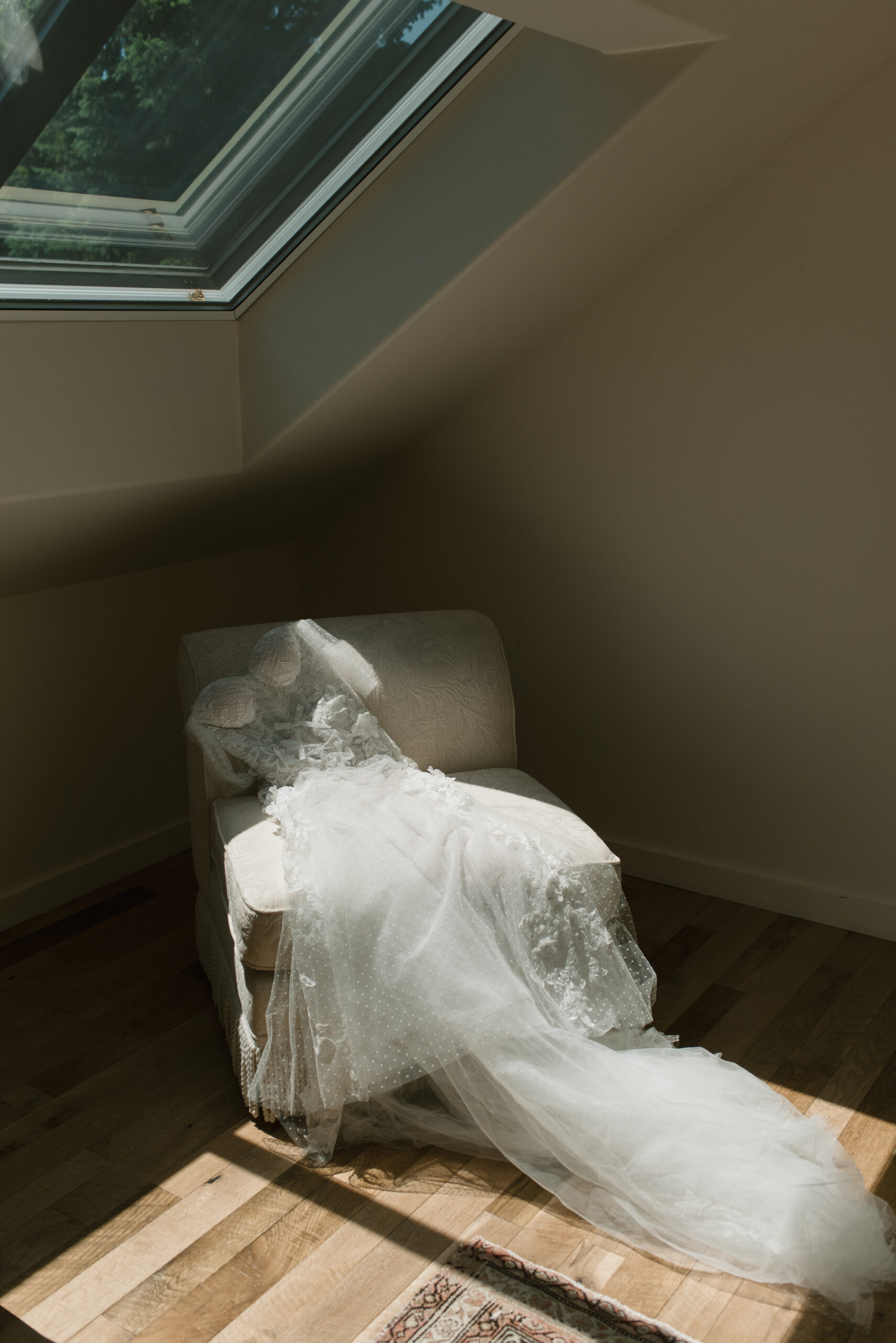 Designer wedding gown laying on a chair catching the light