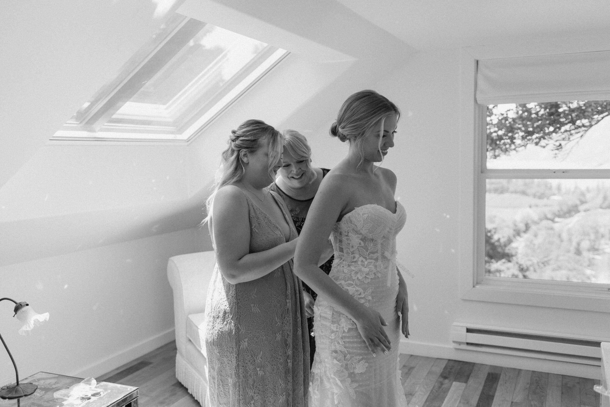 Bride and sister helping her get into her wedding dress