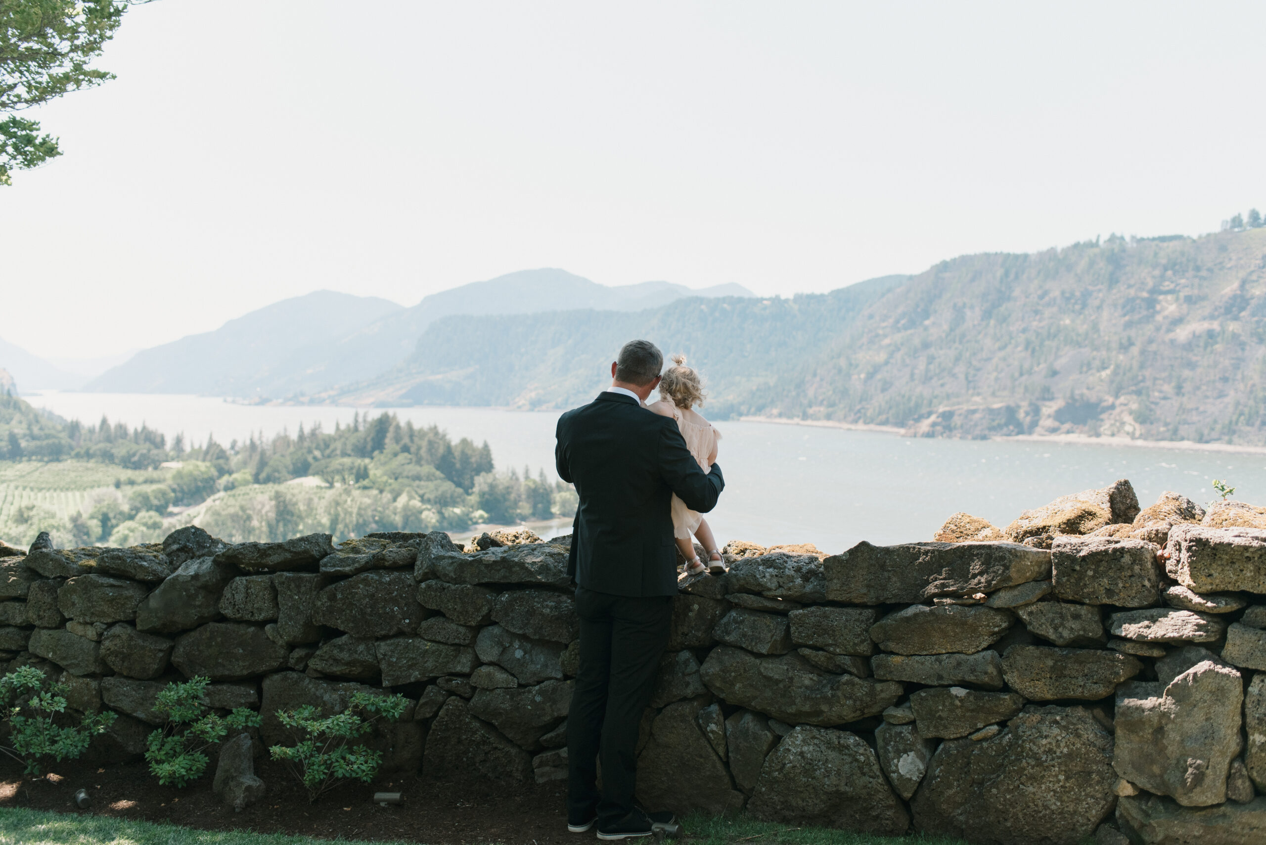 father showing his daughter the columbia river gorge from the griffin house