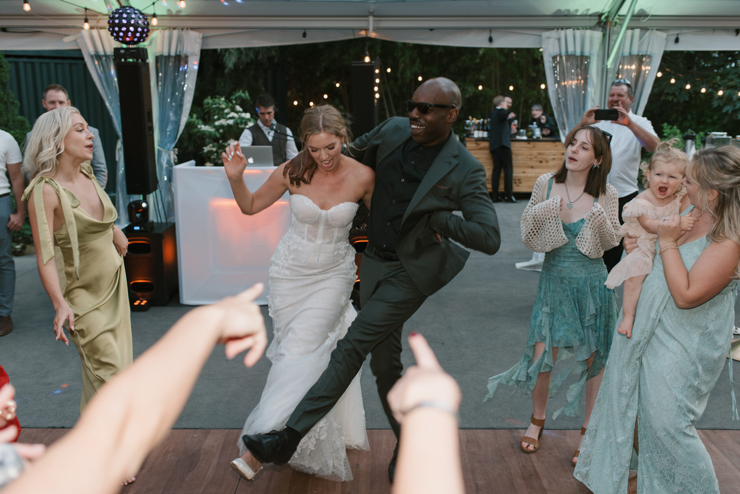 the bride doing a fun dance with a close friend while at a wedding reception