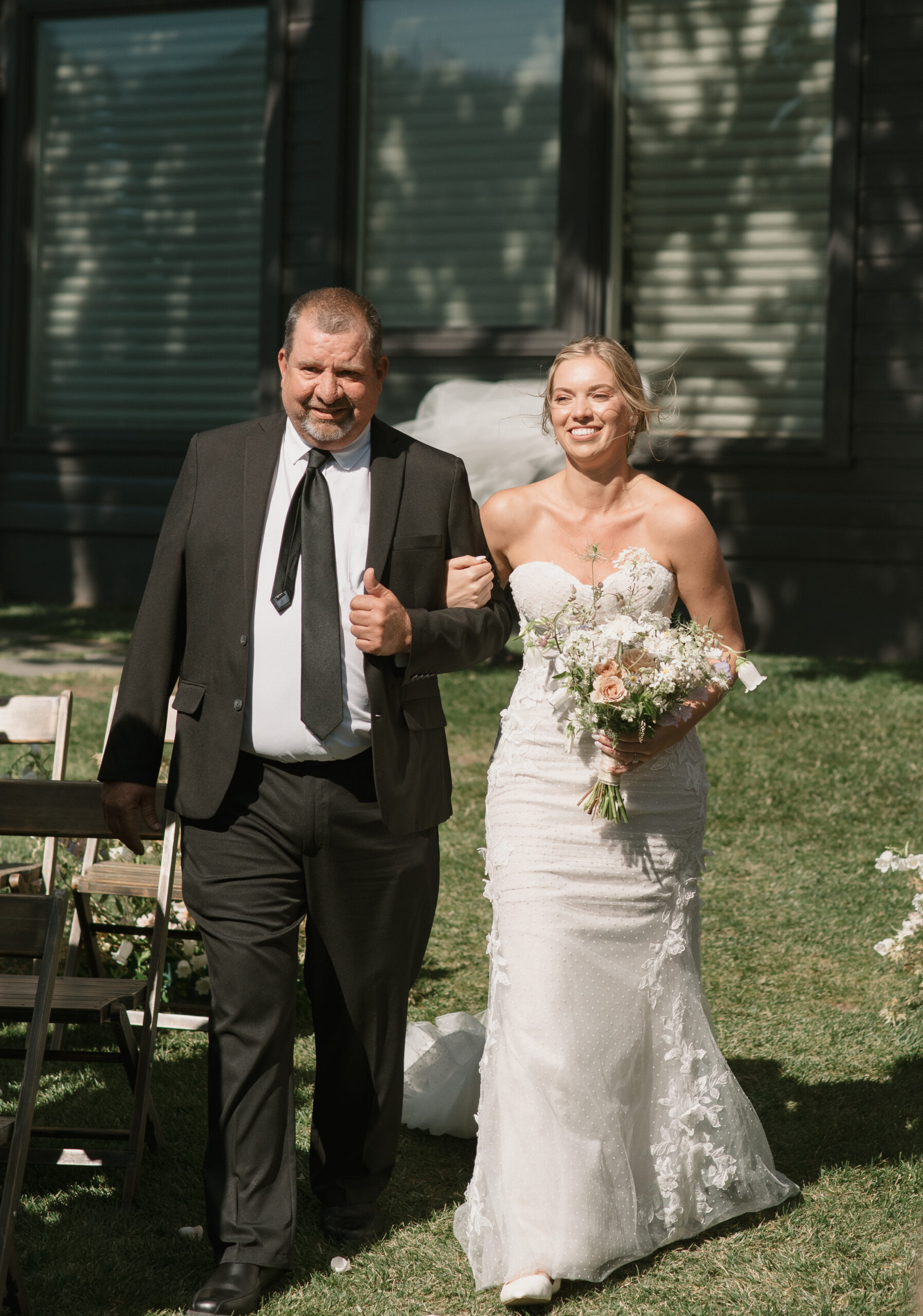 The bride walking down the isle with her father at The Griffin house