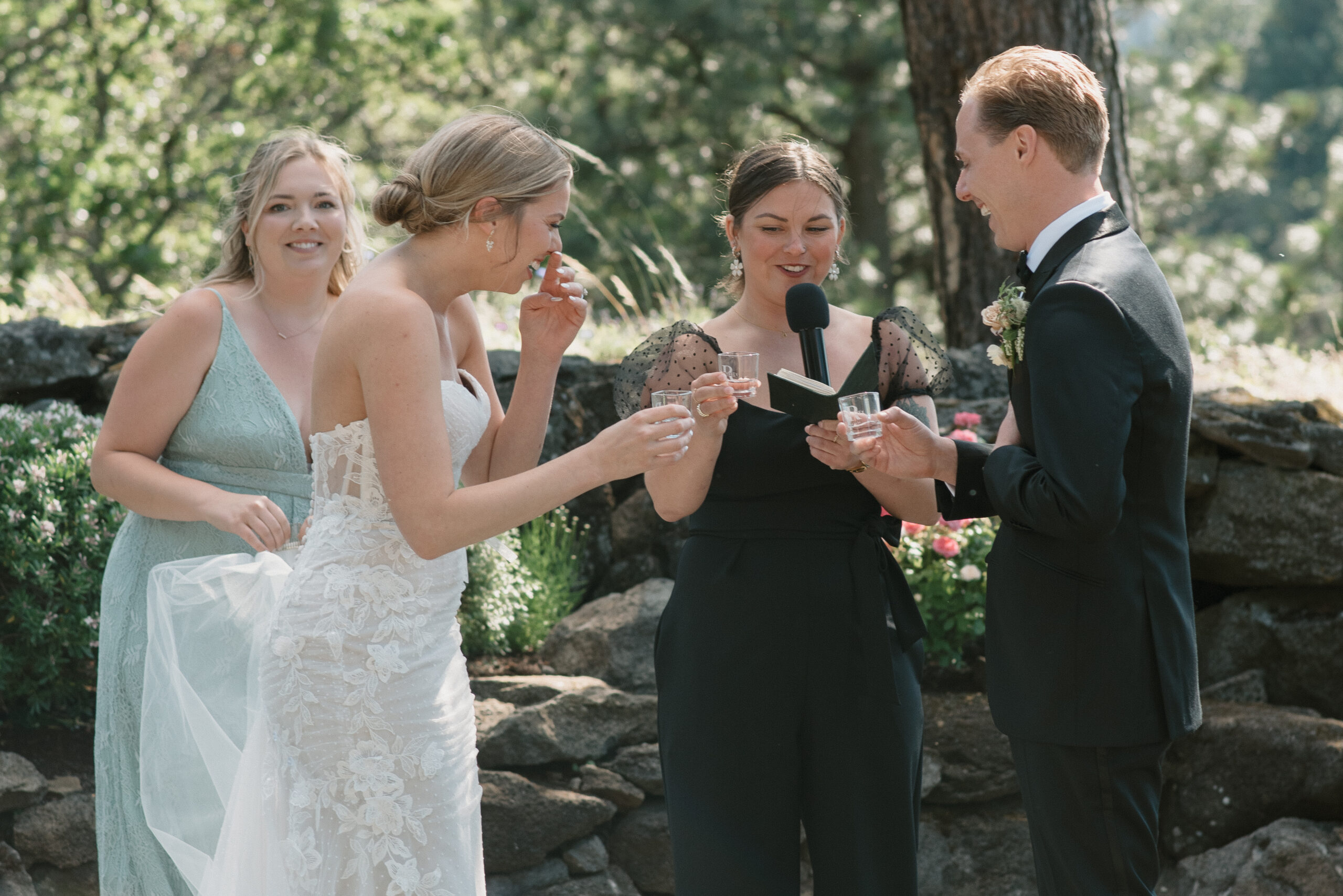 Bride, groom, and officiant talking a shot of tequila during their ceremony