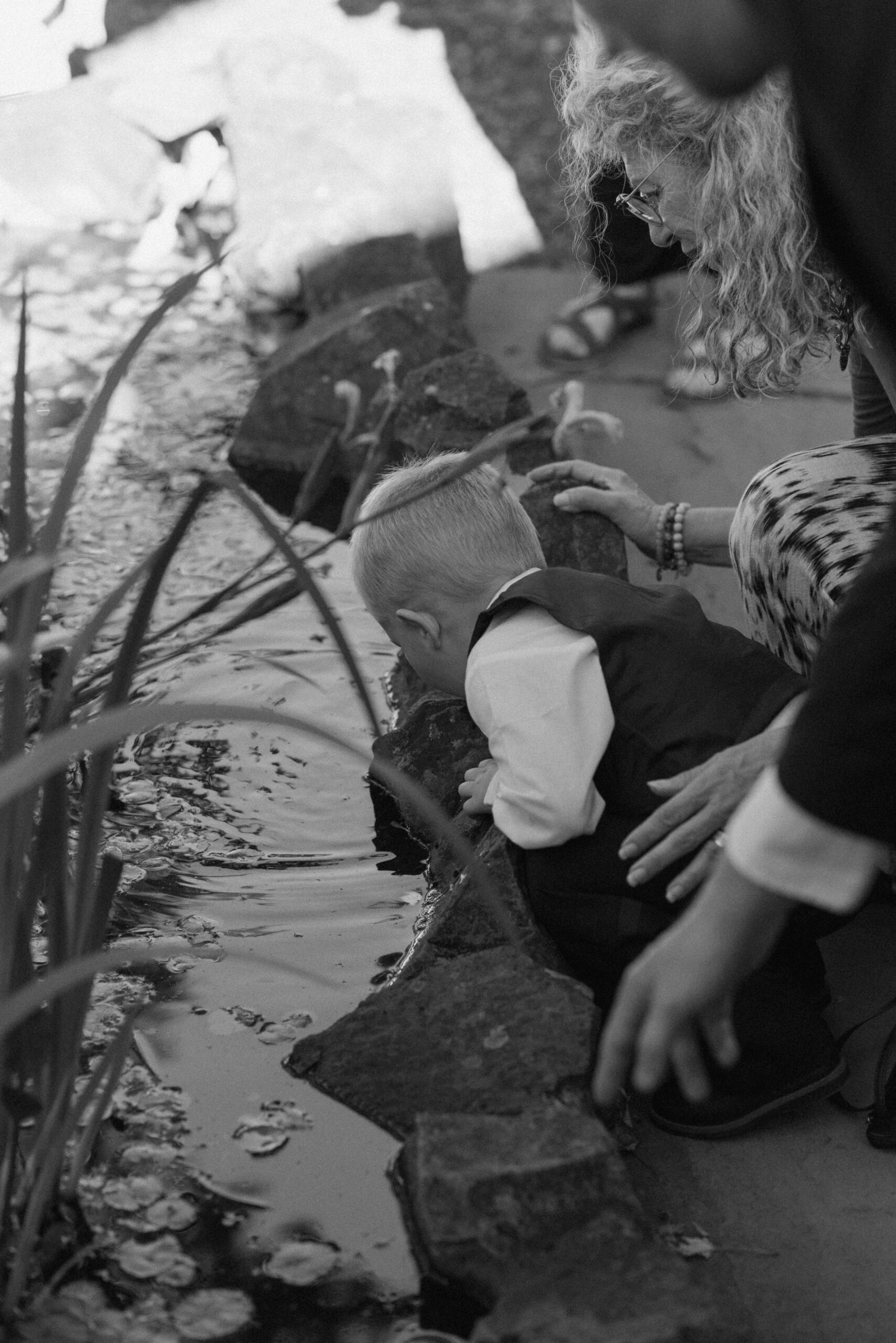 ring bearer playing in the pond at the griffin house