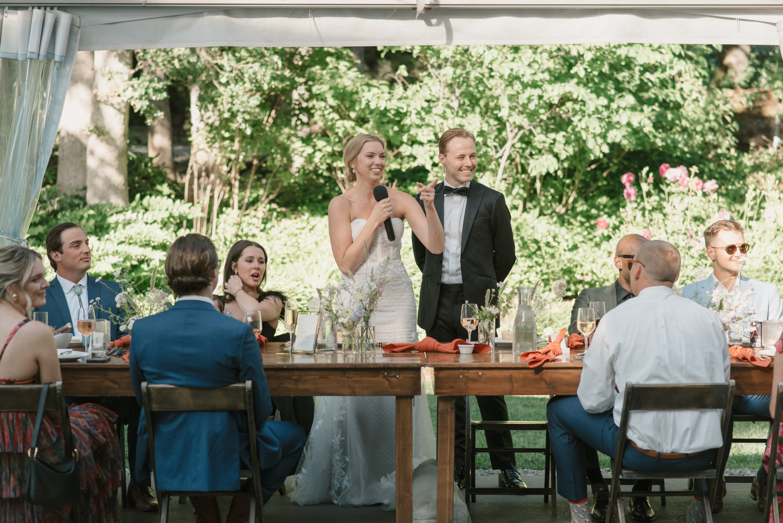 the bride and groom giving a thank you toast to their guests before dinner is served