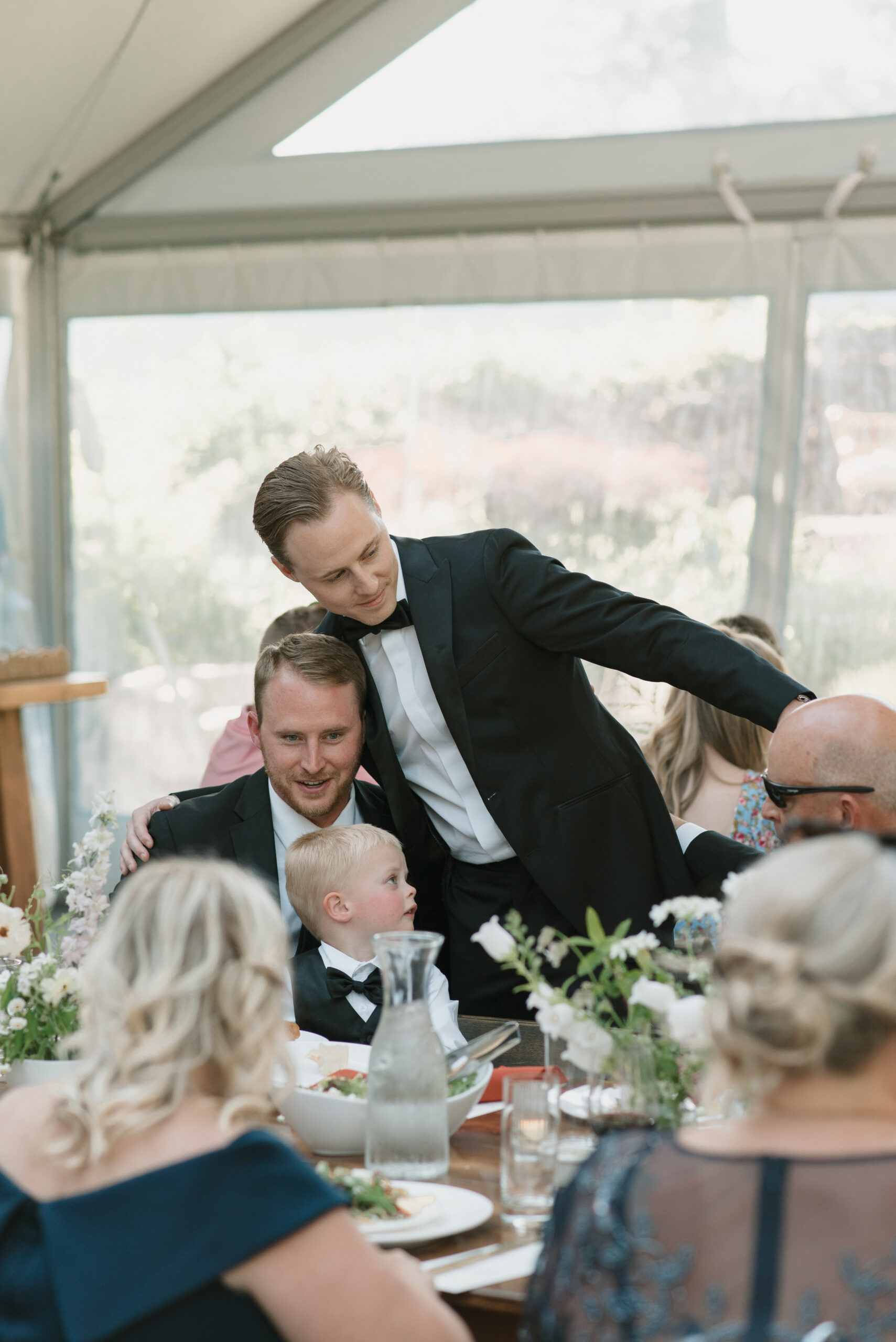 groom hugging his brother at the dinner table